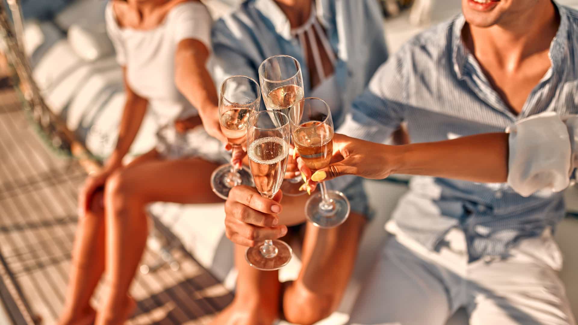 Four friends drinking champagne on a luxury cruise.