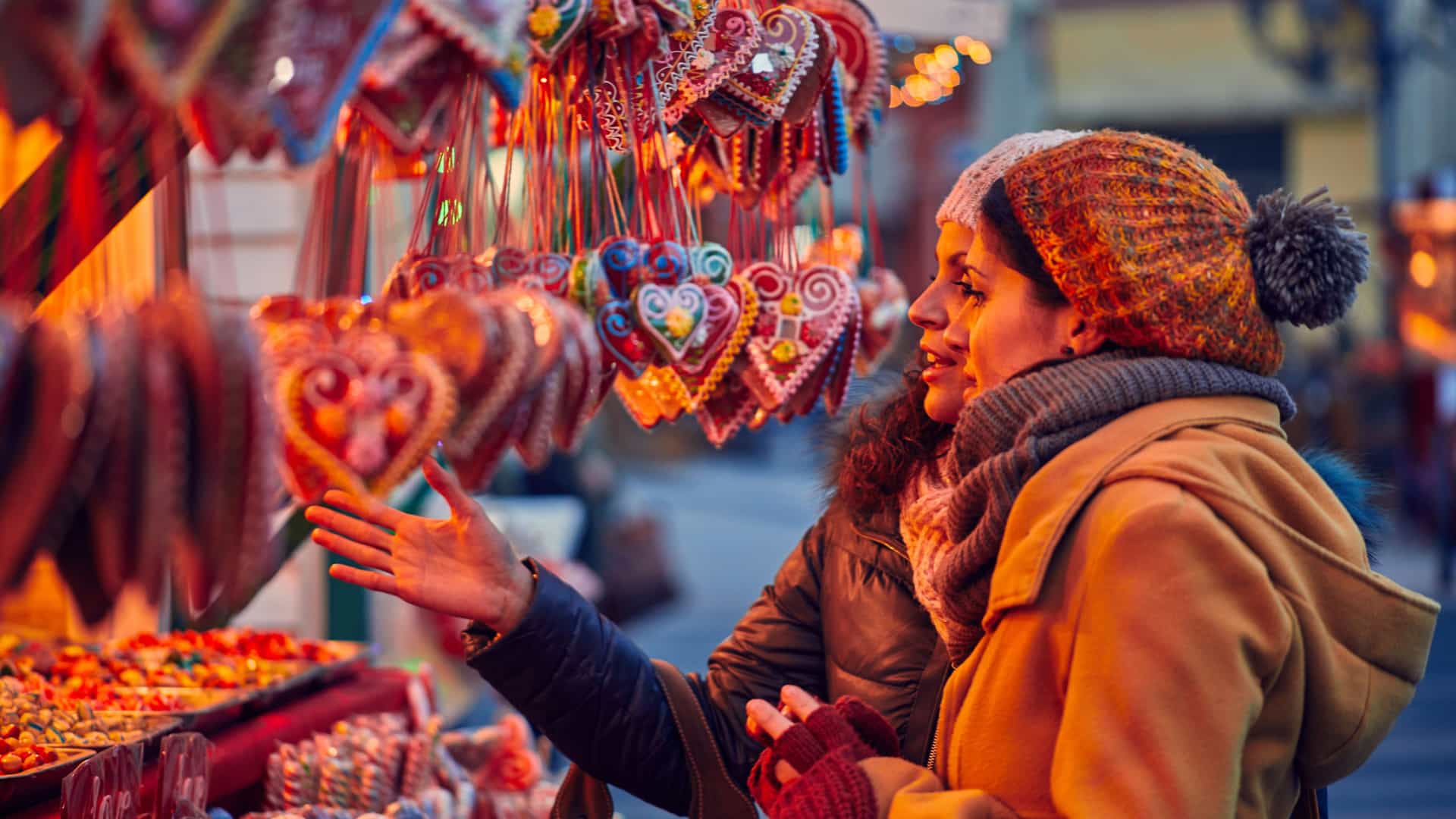Two friends shopping an a booth during a Christmas market in Europe.