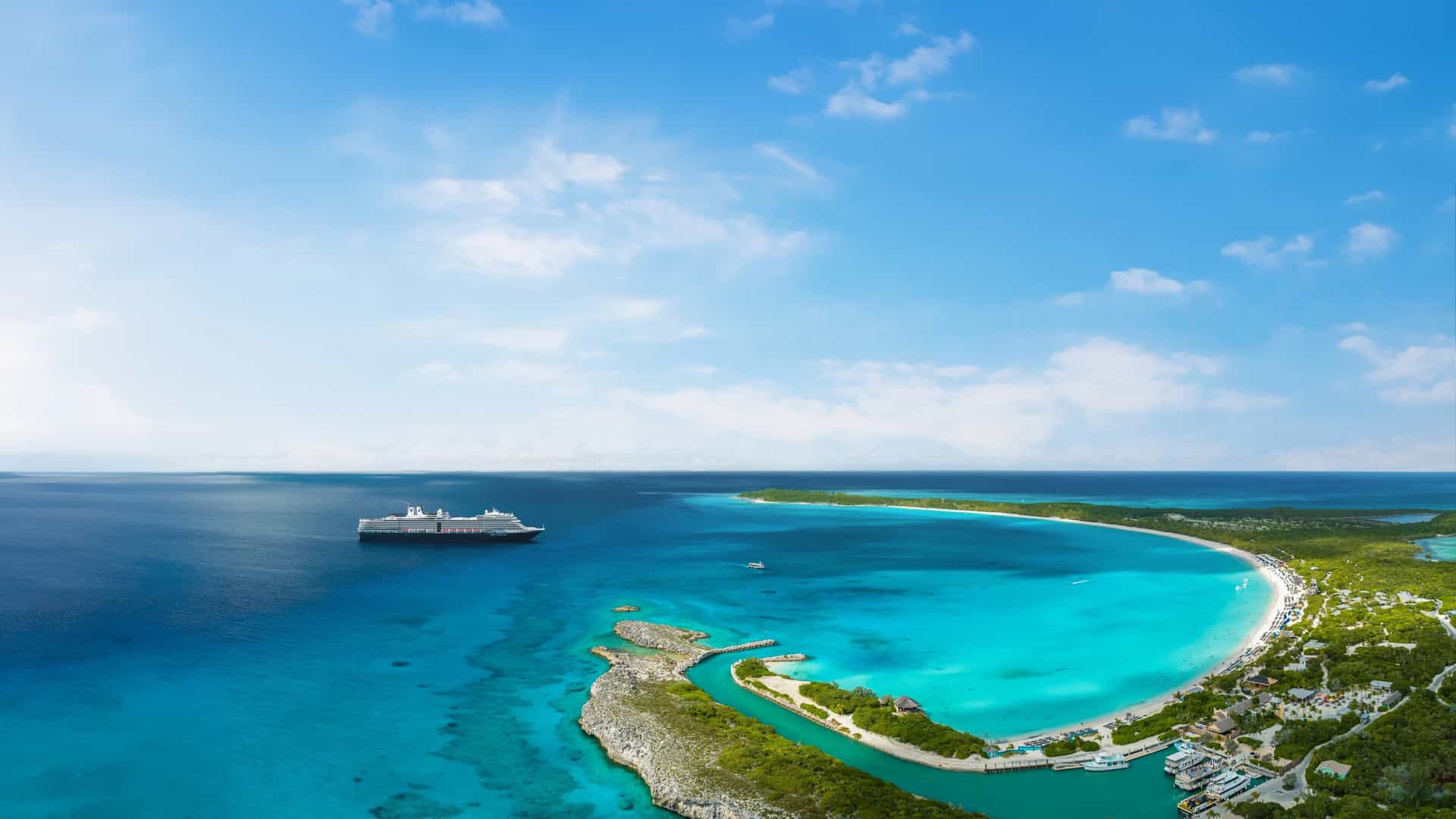 Aerial view of Relax Away, Half Moon Cay in the Bahamas showing a crescent-shaped turquoise lagoon, white sand beach, and a Holland America Line ship anchored offshore.