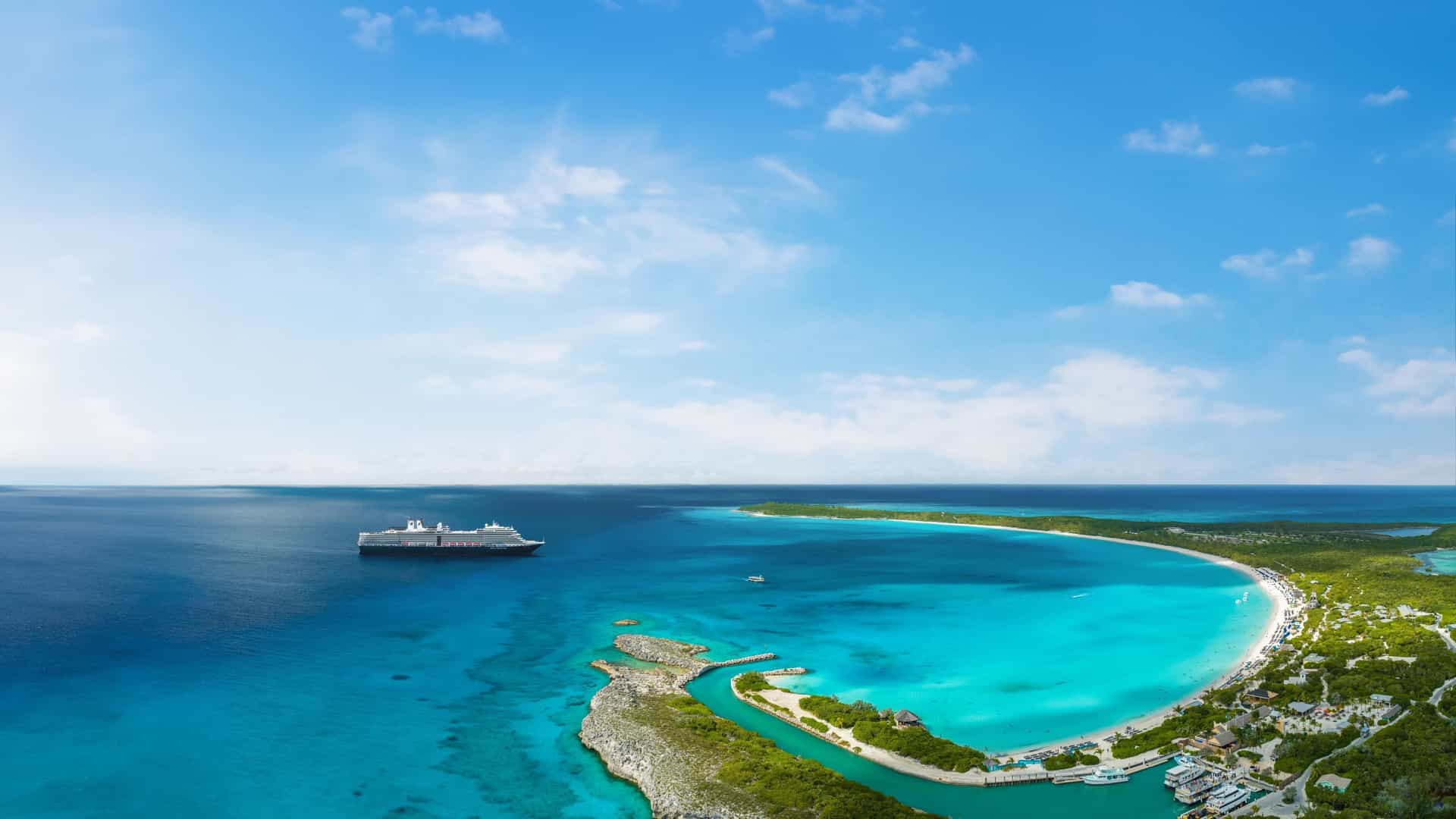 Holland America cruise ship anchored off a pristine tropical island in the Bahamas.