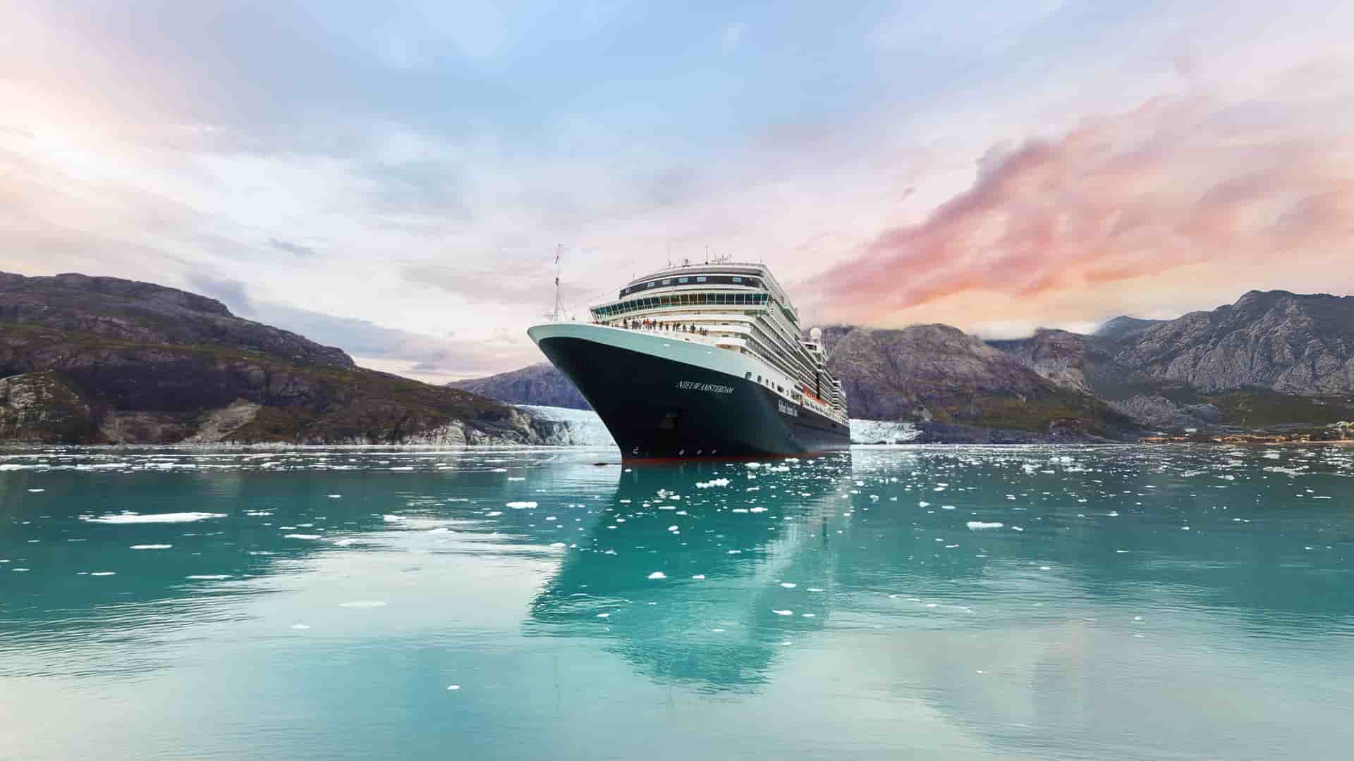 Holland America Line's Nieuw Amsterdam ship navigating an icy Alaskan landscape during a colorful sunset.