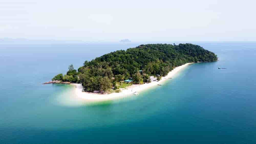 Drone view of Koh Naka Noi Island near Phuket, Thailand, showcasing turquoise waters, white sandy beaches, and lush tropical landscape