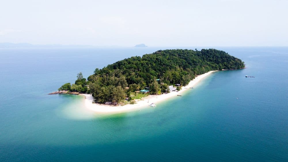 Drone view of Koh Naka Noi Island near Phuket, Thailand, showcasing turquoise waters, white sandy beaches, and lush tropical landscape