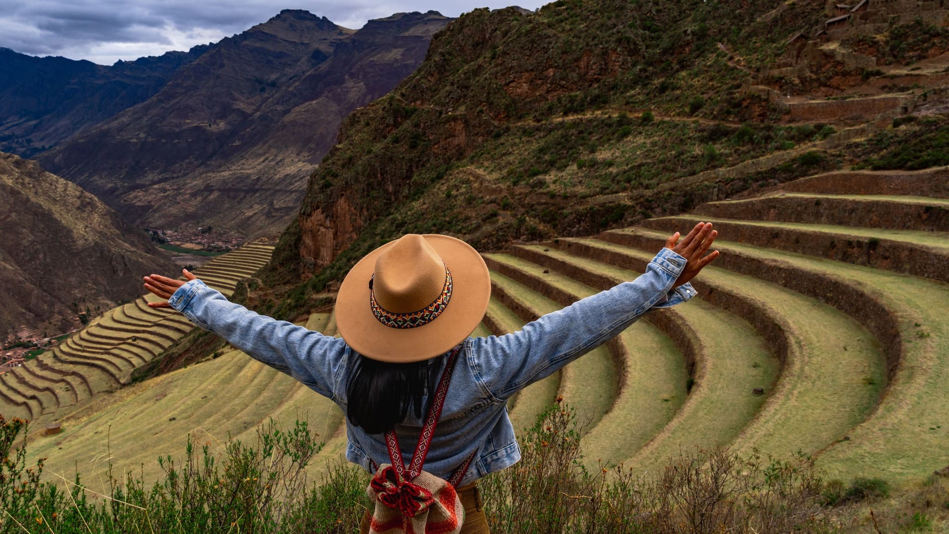 A woman overlooking the Pisac ruins in Cusco, Peru.