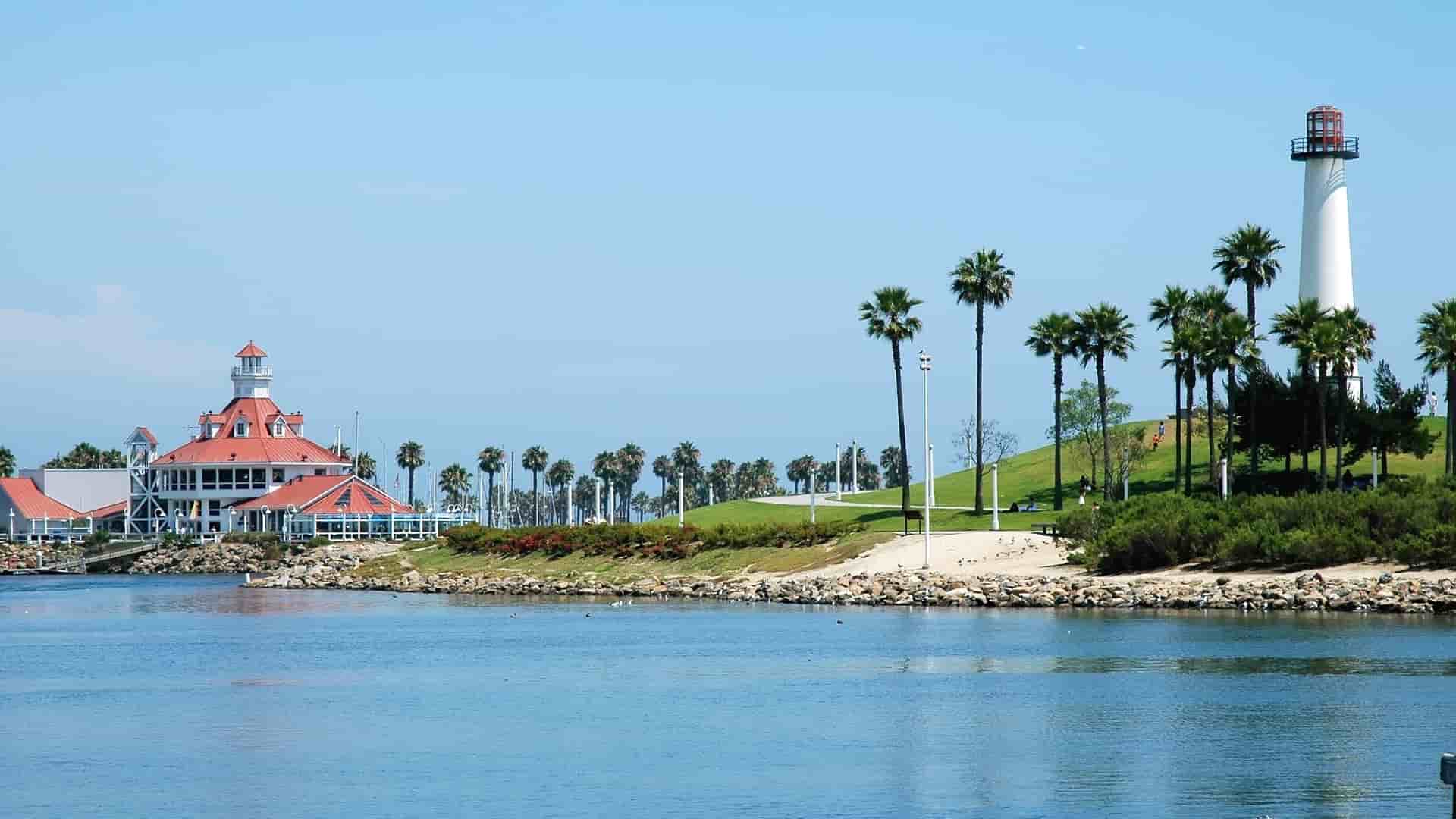 Long Beach, California shoreline with lighthouse and palm trees.
