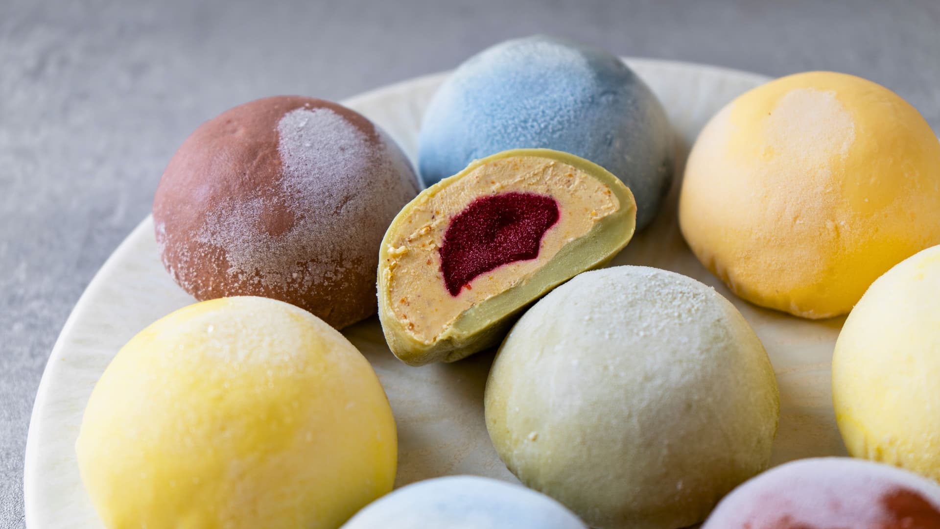 Close up of a colorful assortment of mochi, a traditional Japanese sticky rice dessert with ice cream added inside.