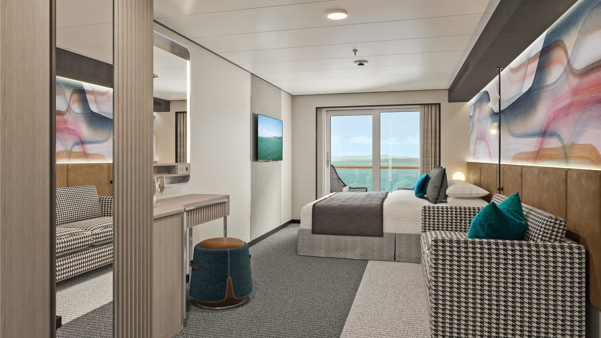Modern balcony stateroom on Norwegian Aqua featuring a king bed, patterned sofa, vanity area and glass sliding doors opening to ocean views.
