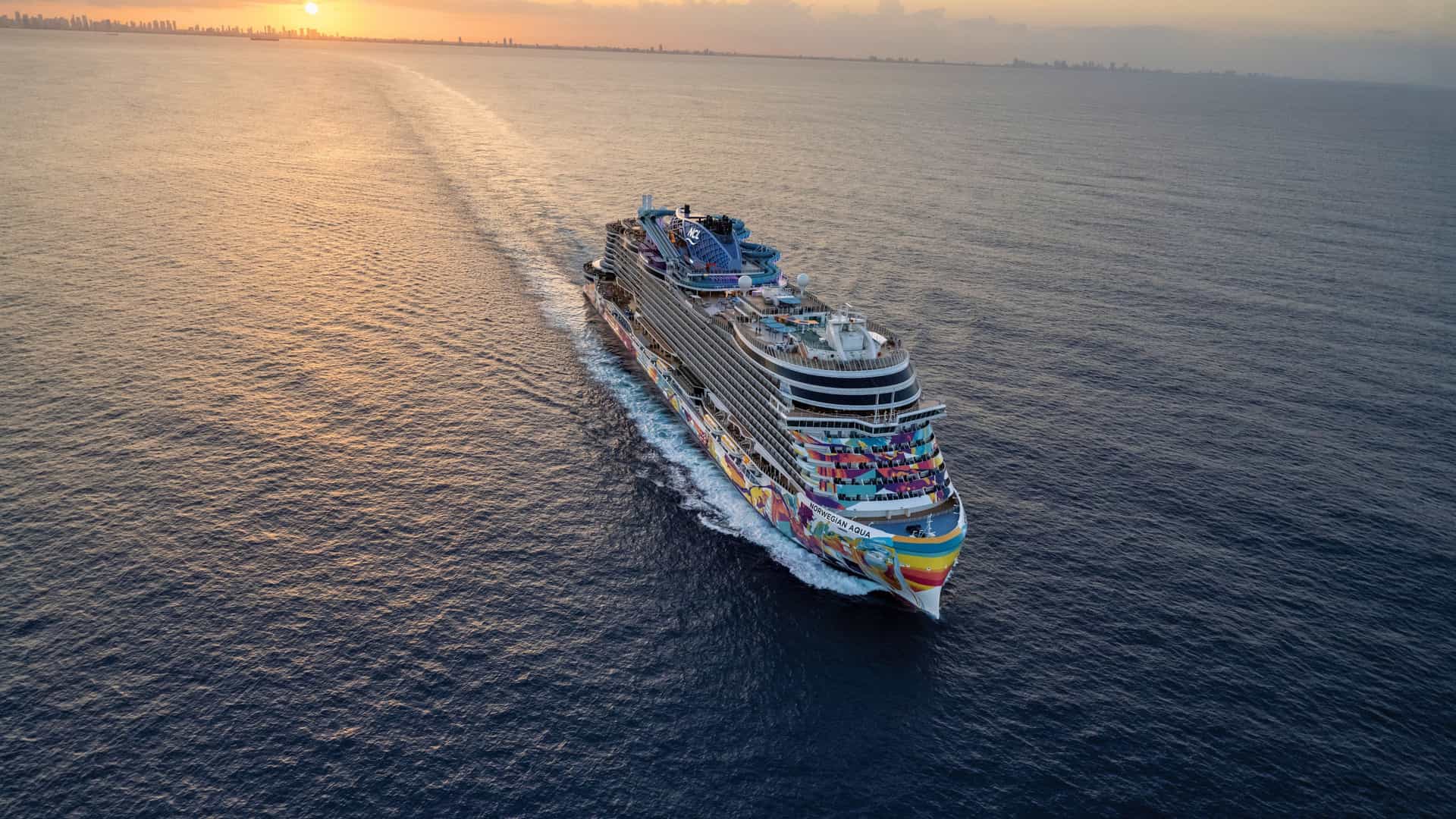 Aerial view of the Norwegian Aqua cruise ship departing Miami, Florida, at sunset, beginning or ending a Norwegian Cruise Line repositioning itinerary.