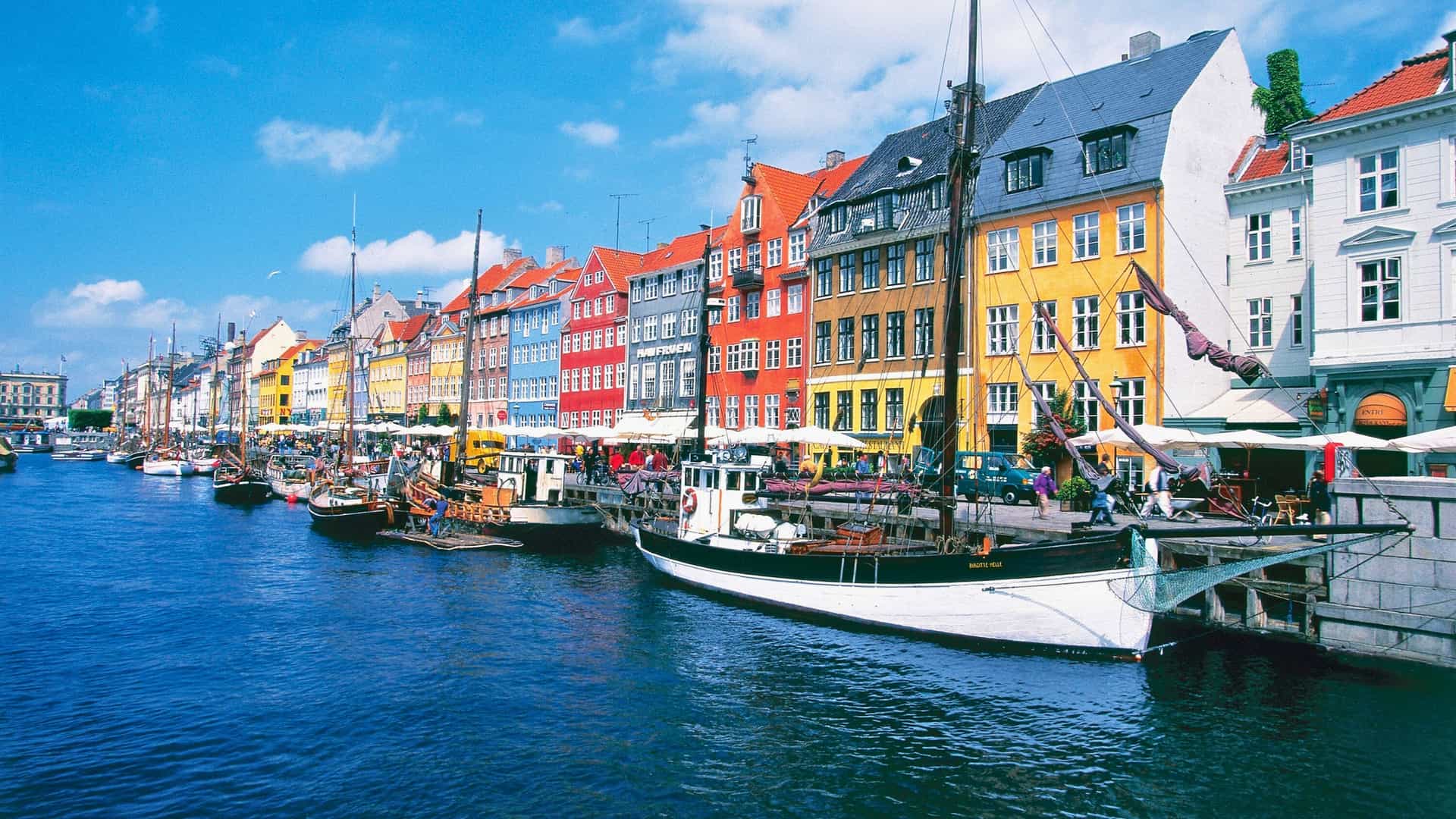 Norwegian Cruise Line destination of Nyhavn canal in Copenhagen, Denmark, a charming waterfront in Northern Europe with vibrant colorful buildings and historic ships.