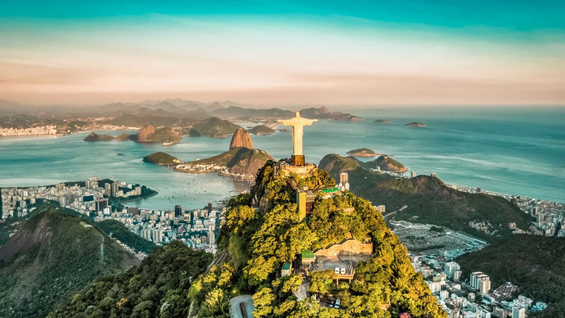 An Oceania Cruises perspective of Rio de Janeiro, Brazil, a vibrant South America destination, featuring the iconic Christ the Redeemer statue overlooking Sugarloaf Mountain and Botafogo Bay.