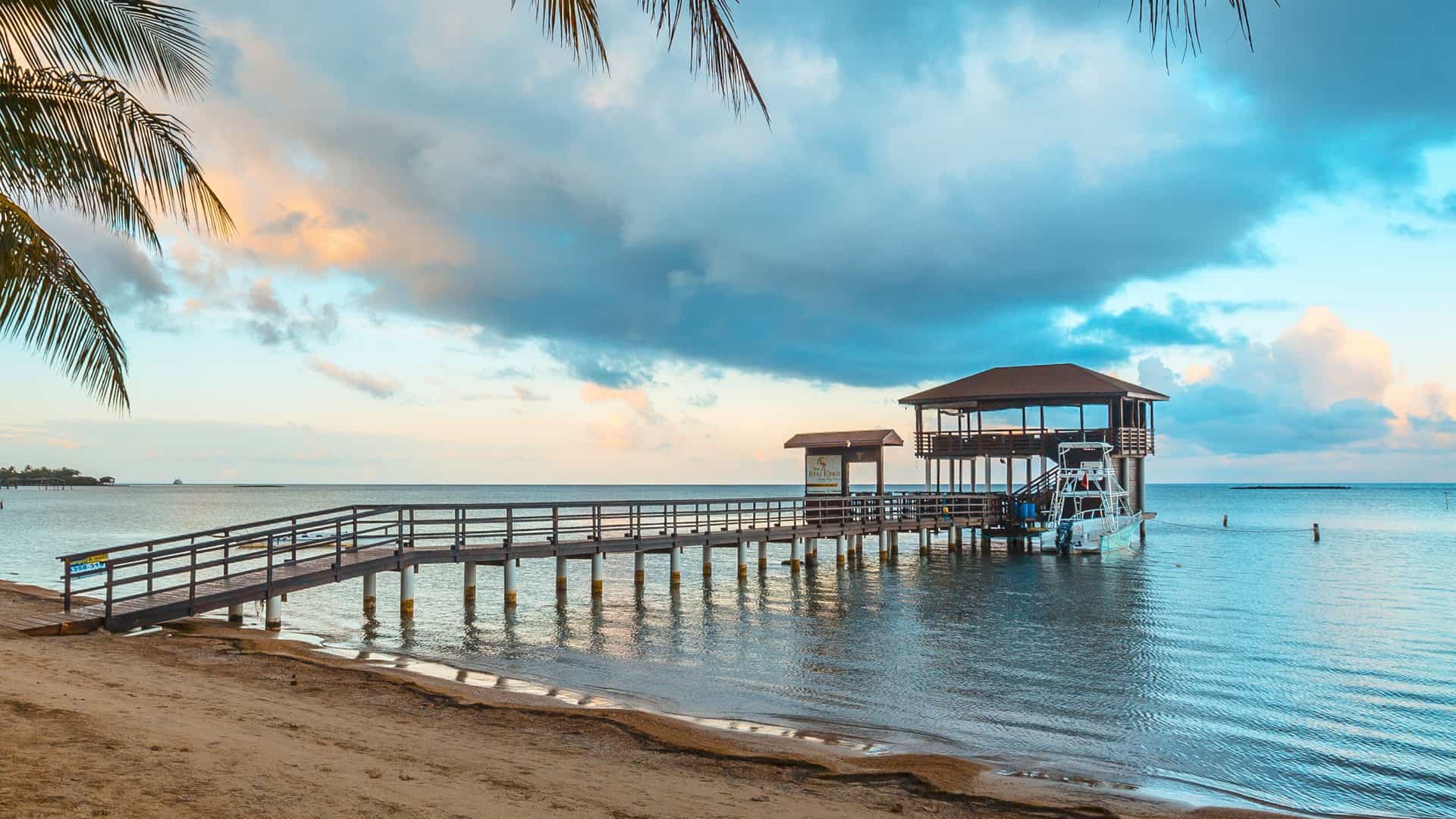 Experience the serene beaches and picturesque pier of Roatán, Honduras, a captivating Western Caribbean destination on an Oceania Cruises itinerary.