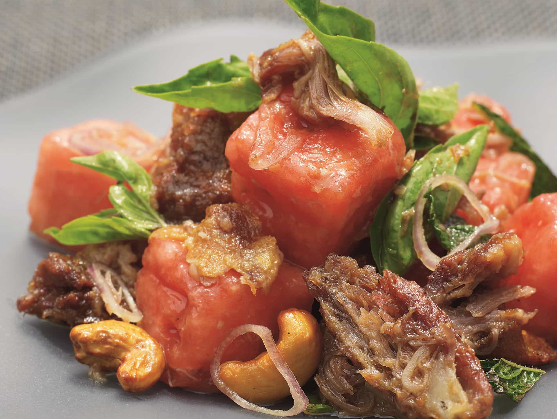 Spicy roast duck and watermelon salad with cashews, fresh basil, and shaved red onion served at Red Ginger on Oceania Cruises.