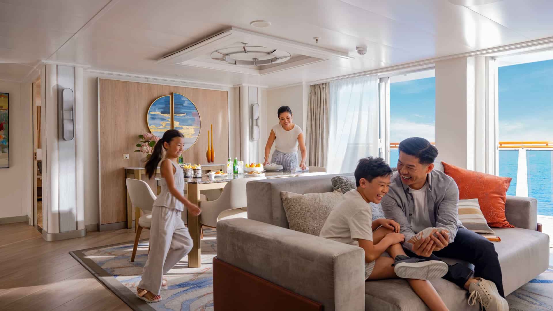 Family relaxing in a spacious Sky Suite living area on Sun Princess, with a private balcony and ocean views.