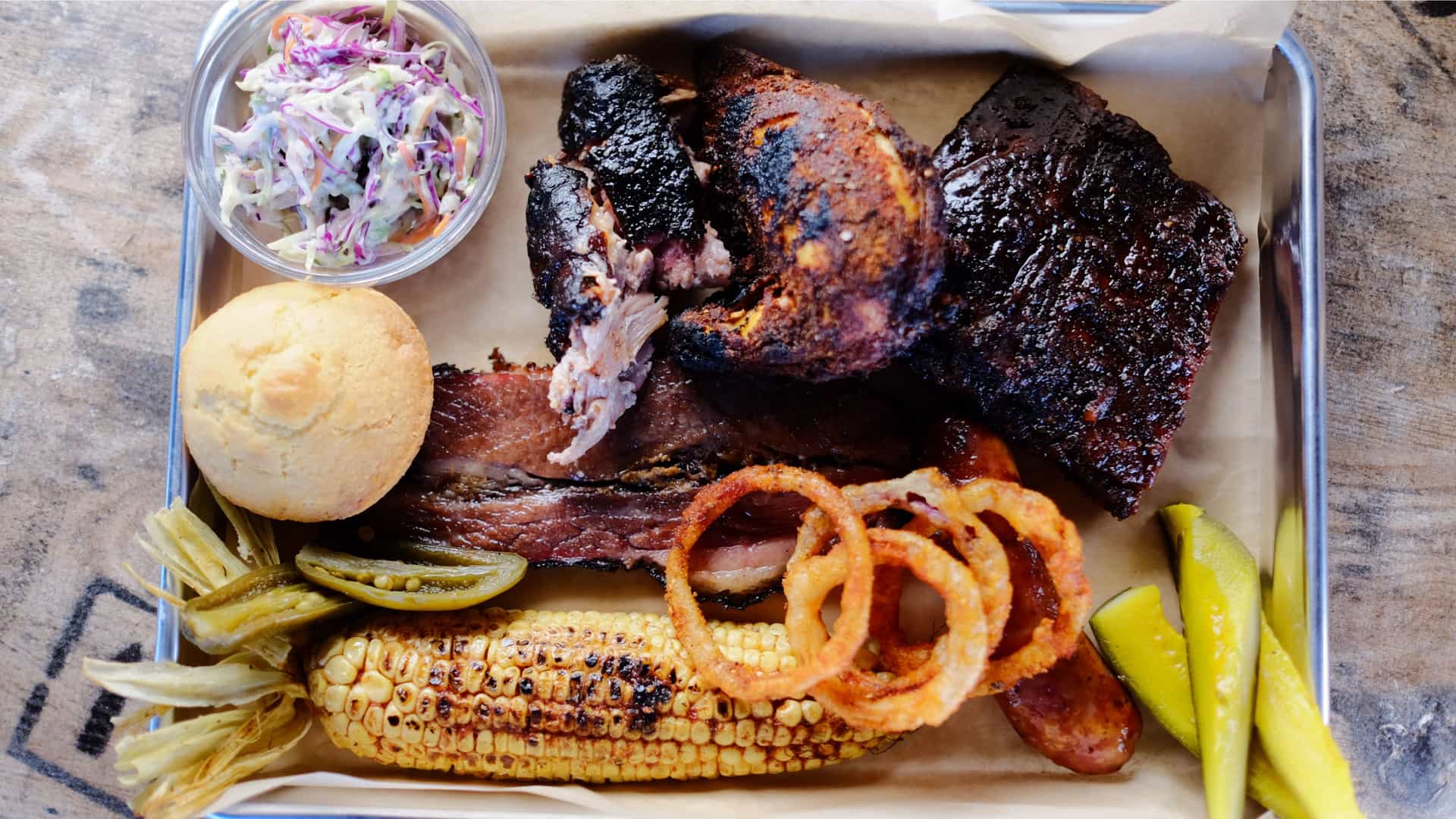 A tray of BBQ, corn, onion rings, coleslaw and more at Pig & Anchor BBQ on a Carnival cruise.
