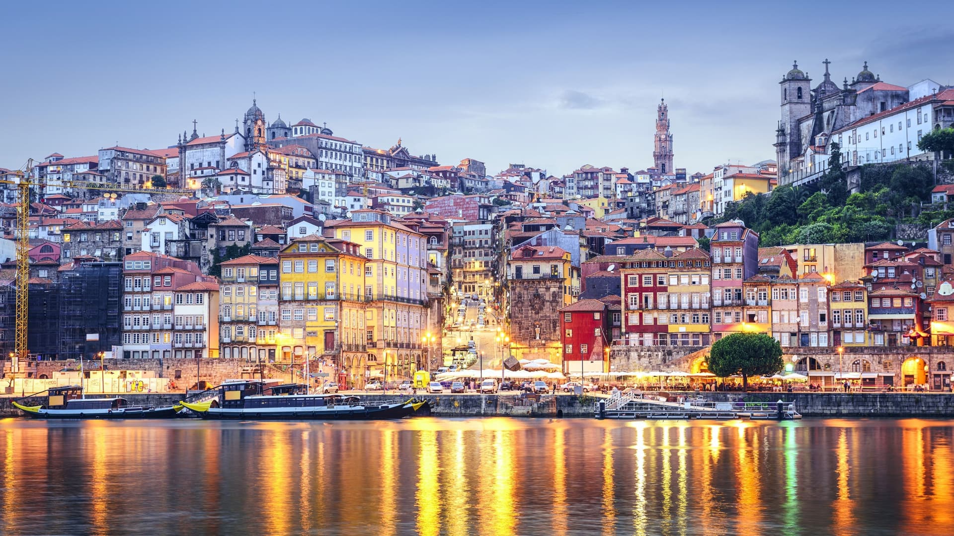 Historic cityscape of Porto, Portugal, along the Douro River at dusk.