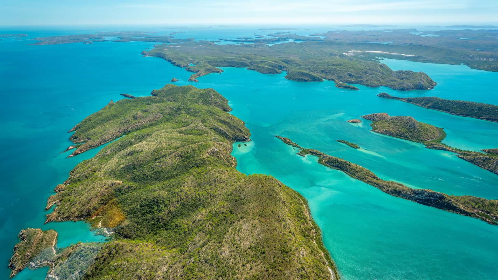 An aerial view of the Buccaneer Archipelago, featuring rugged, green islands and turquoise waters of the Indian Ocean, a popular sailing destination.