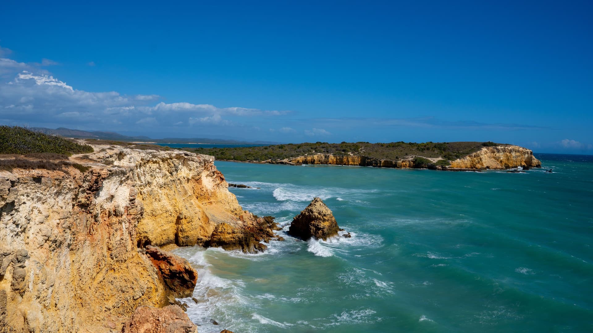 A breathtaking view of the Los Morrillos Lighthouse and the rugged coastline of Cabo Rojo, Puerto Rico, with dramatic cliffs and turquoise water.