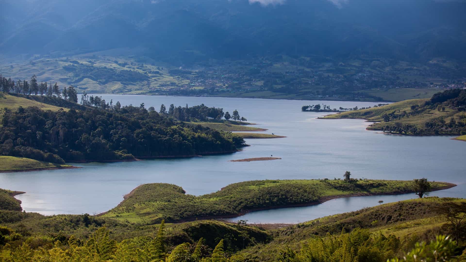 Scenic aerial view of Lago Calima reservoir nestled among the green hills and Western Andes Mountains in Darién, Colombia.
