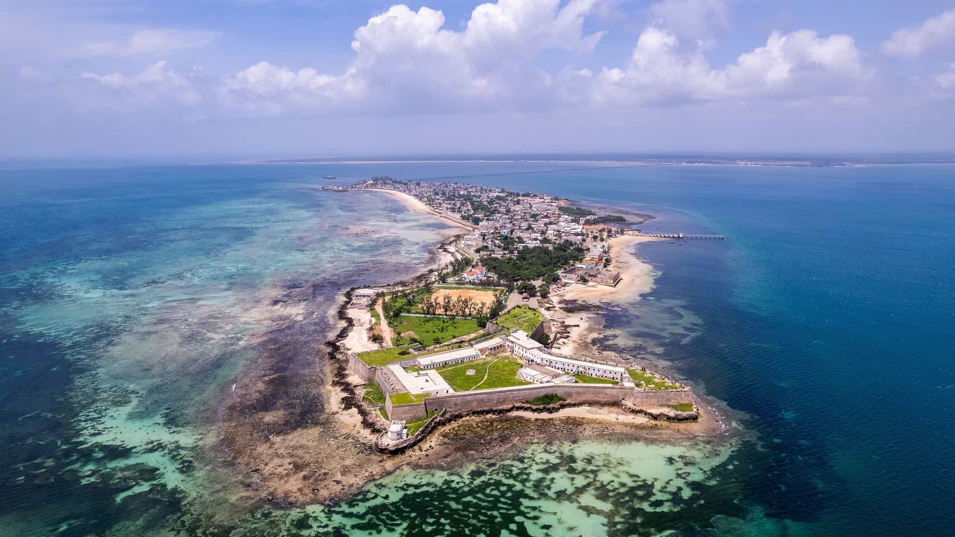 An aerial view of the Island of Mozambique, a UNESCO World Heritage site, with the historic Fort São Sebastião in the foreground and the city stretching along the coast.