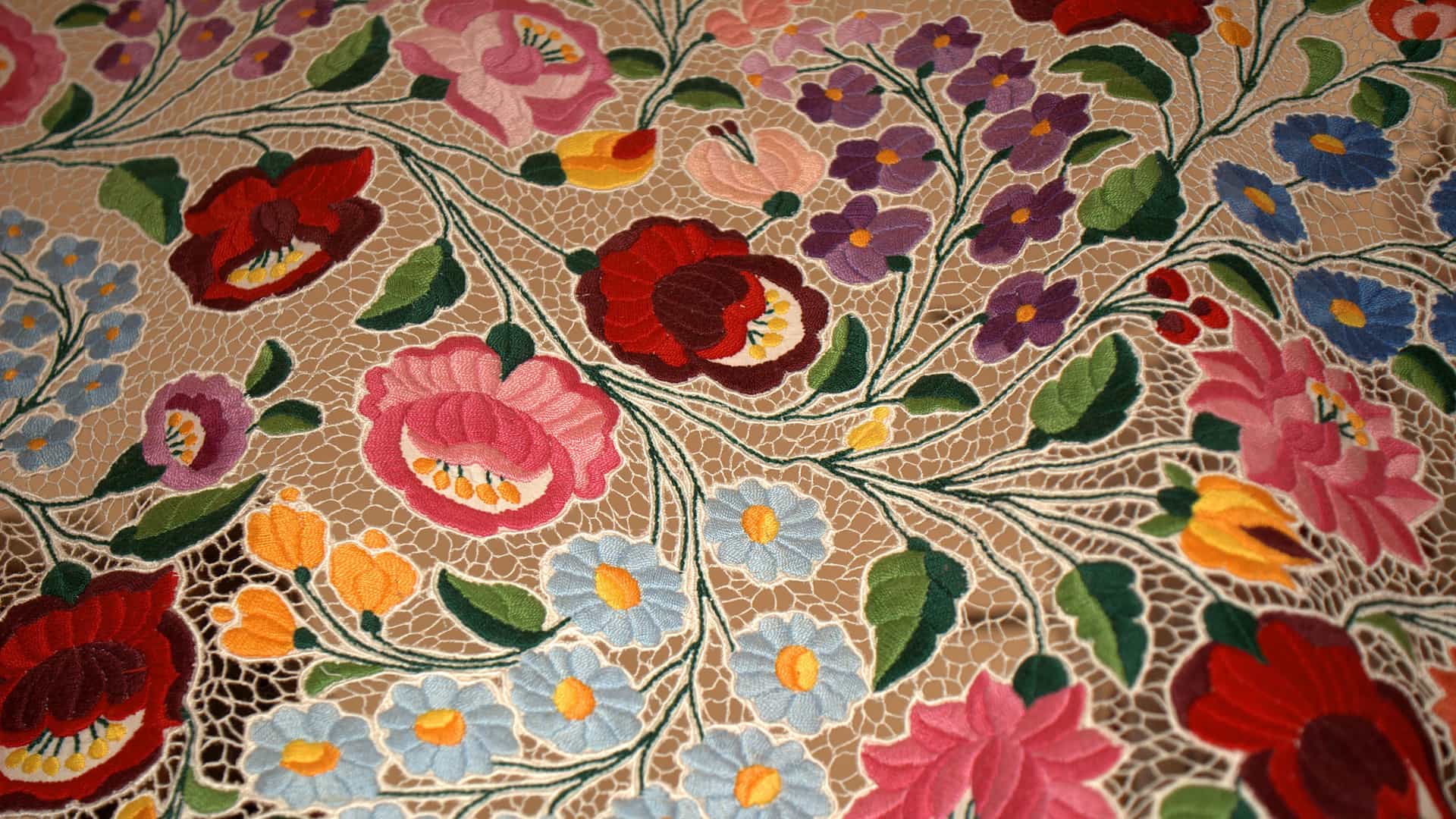 A close-up of a traditional Kalocsa embroidery, showcasing vibrant, colorful floral patterns and intricate needlework, a prominent folk art of Hungary.