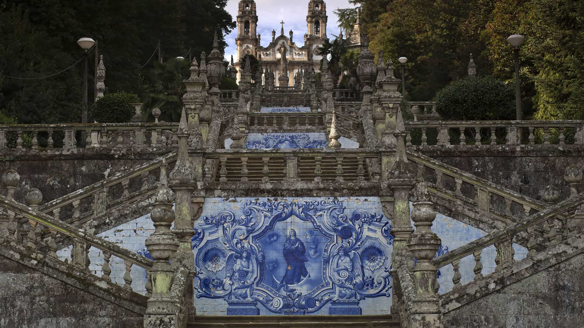 A detailed view of the ornate blue and white tilework on the grand, baroque-style double staircase leading to the Sanctuary of Our Lady of Remedies church in Lamego, Portugal.