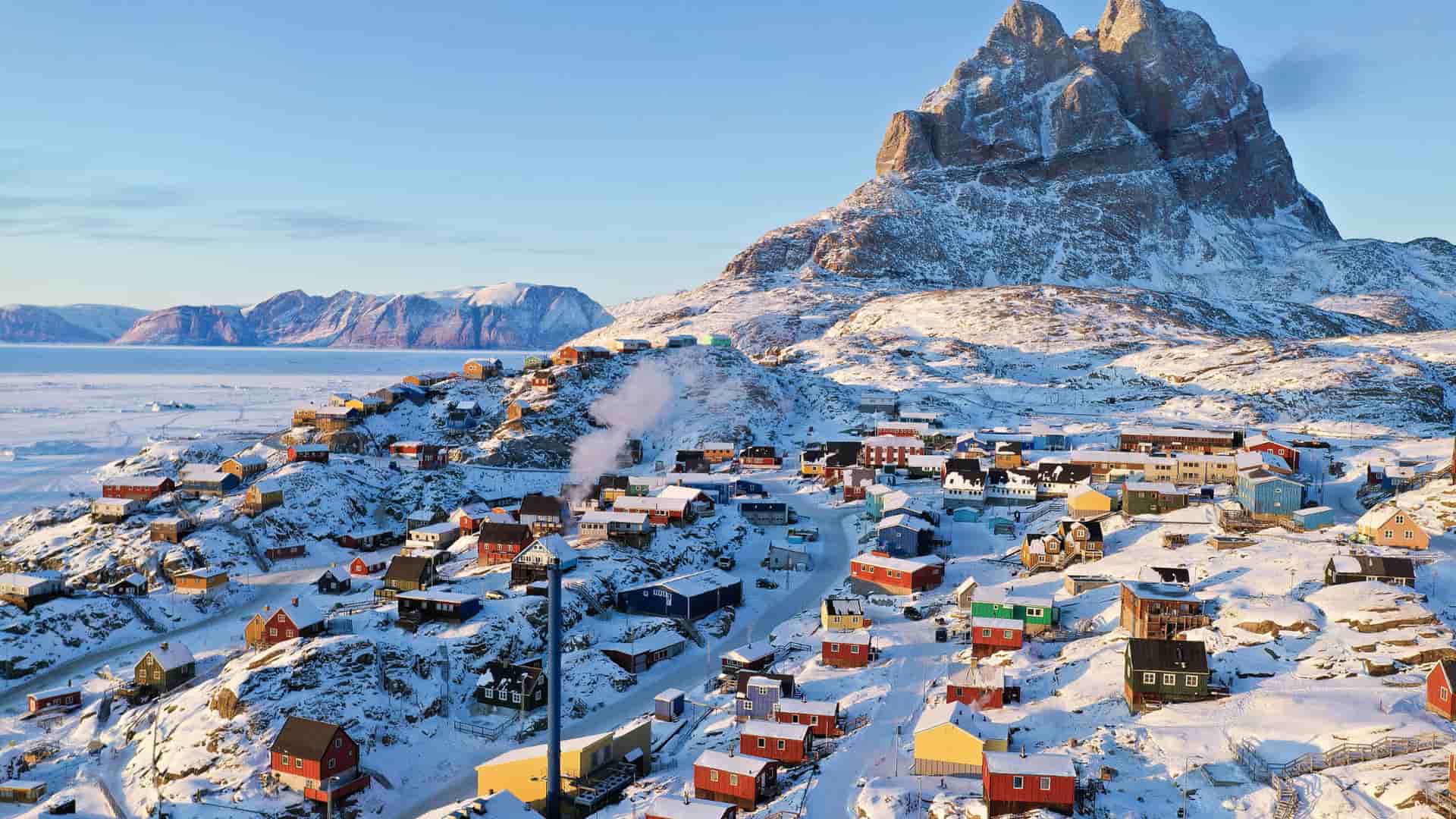 "A beautiful aerial view of the colorful, snow-covered houses of the small village of Uummannaq, Northwest Greenland, at the foot of the magnificent Uummannaq Mountain. "