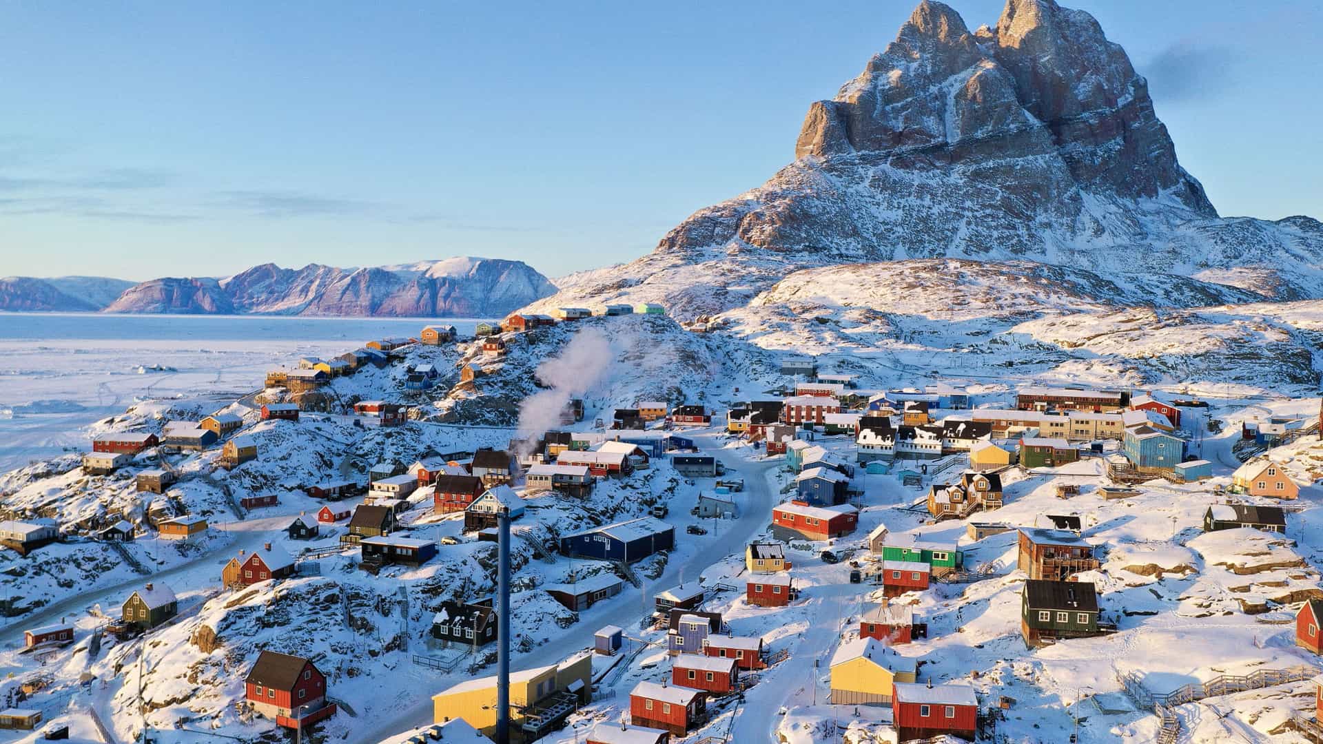 "A beautiful aerial view of the colorful, snow-covered houses of the small village of Uummannaq, Northwest Greenland, at the foot of the magnificent Uummannaq Mountain. "