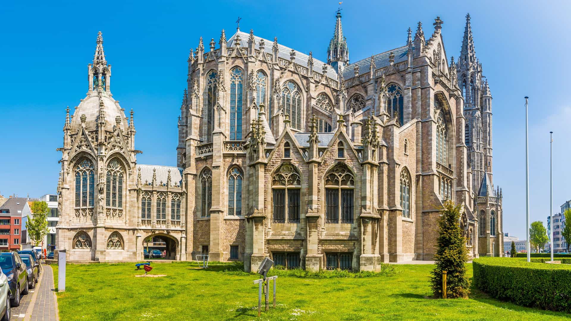 "A stunning wide-angle shot of the historic neo-gothic Saint Peter and Saint Paul Church, a major landmark in Ostend, Belgium, under a clear blue sky. "