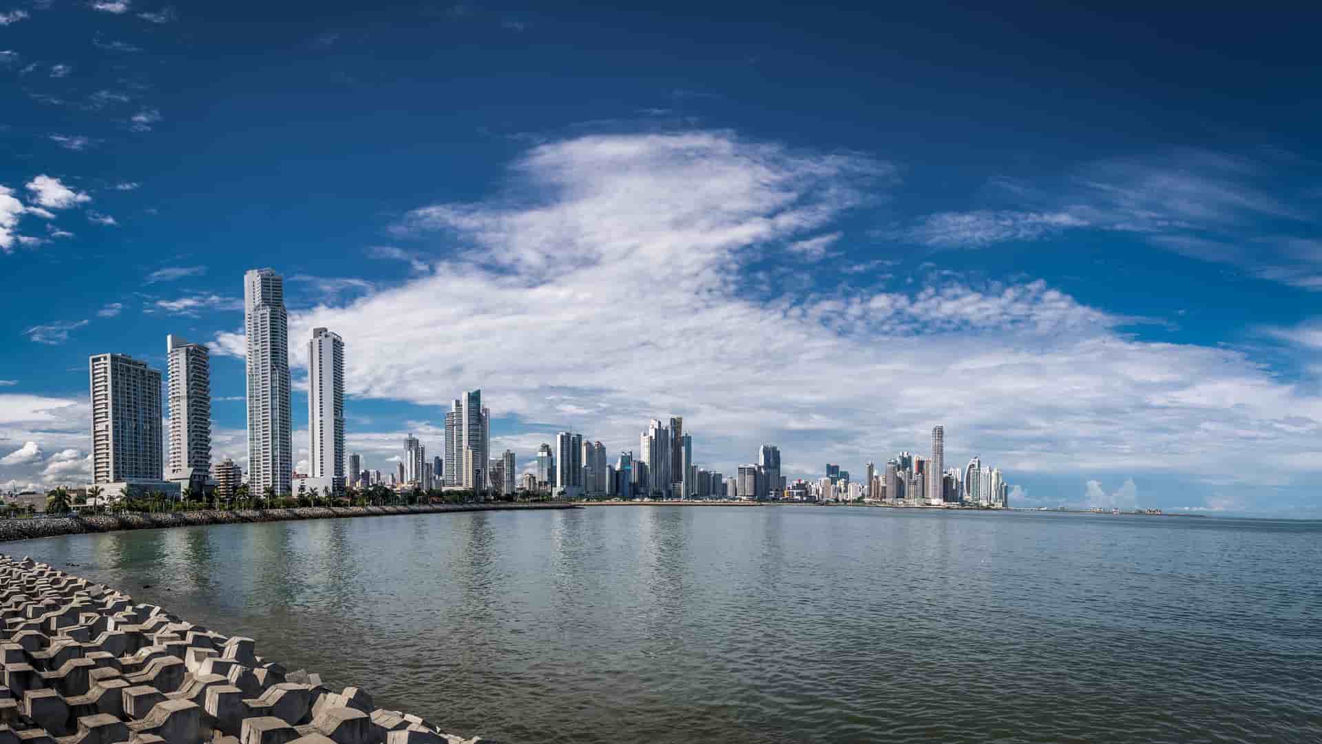 "A scenic panoramic view of the Panama City skyline on the Pacific Coast, with its modern skyscrapers and financial district reflected in the calm waters of the Pacific Ocean. "