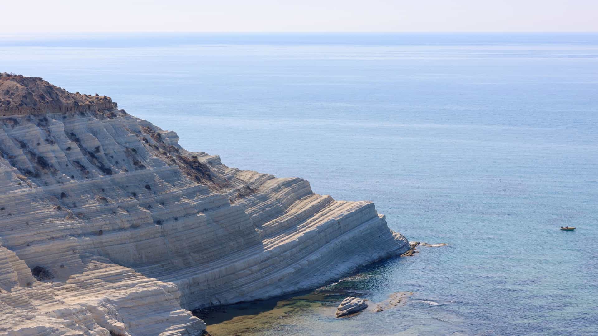 A stunning close-up of the Scala dei Turchi white marl cliff near Porto Empedocle, Sicily, jutting out into the crystal-clear turquoise Mediterranean Sea.