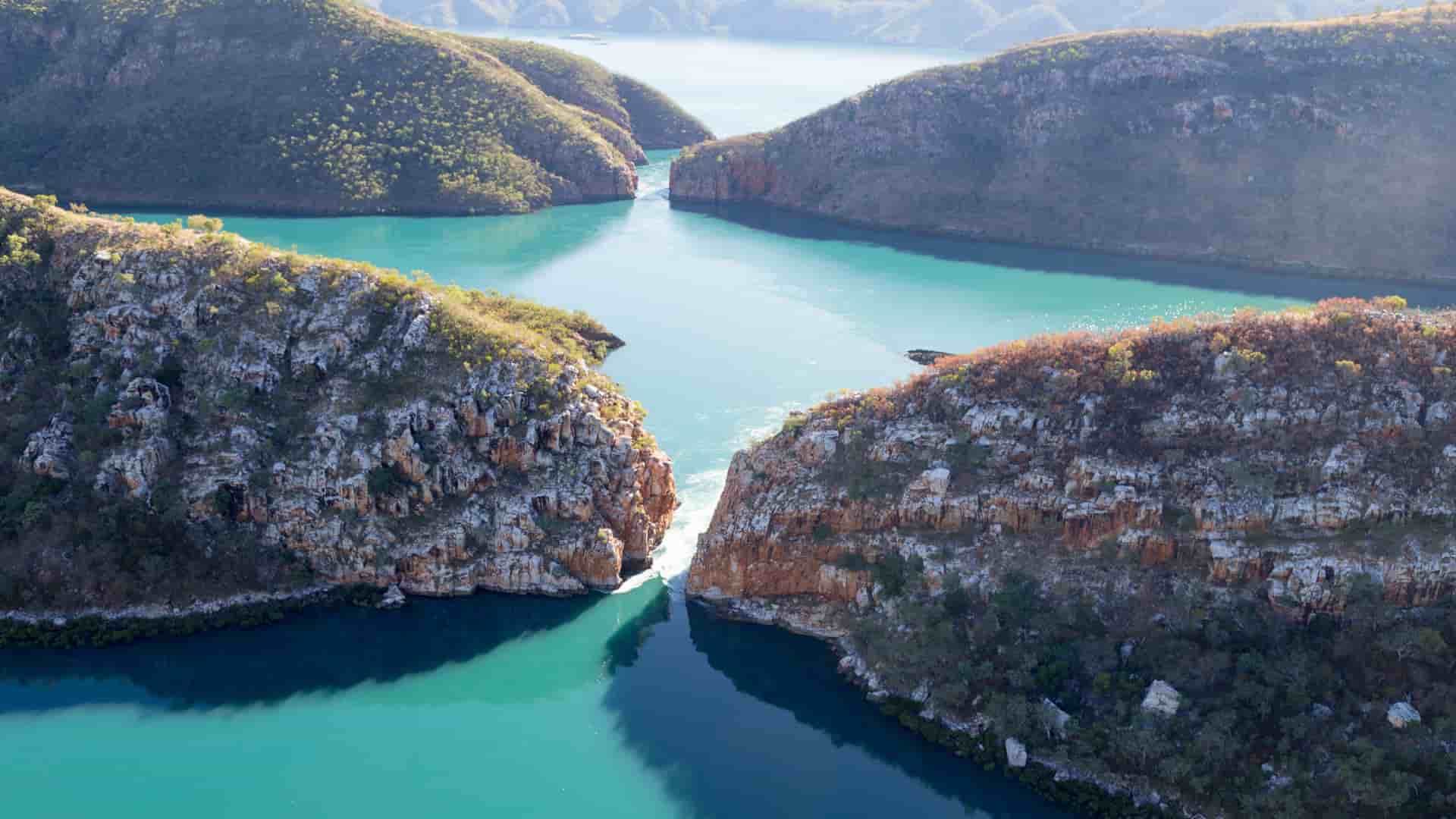 A scenic aerial view of the famous Horizontal Falls in Talbot Bay, Australia, with a powerful tidal flow creating a waterfall effect between two narrow gorges.