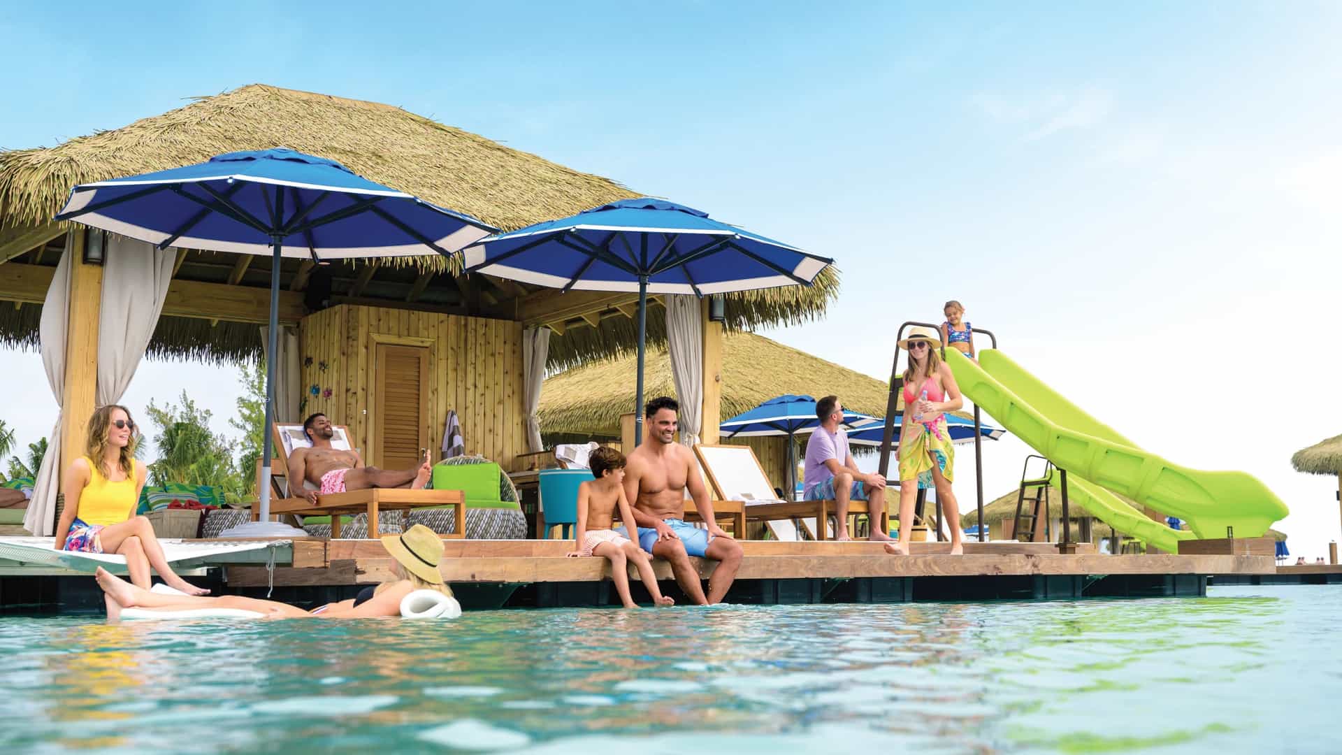 A group of people relaxing in an overwater cabana at Cococay, Royal Caribbean's private island.