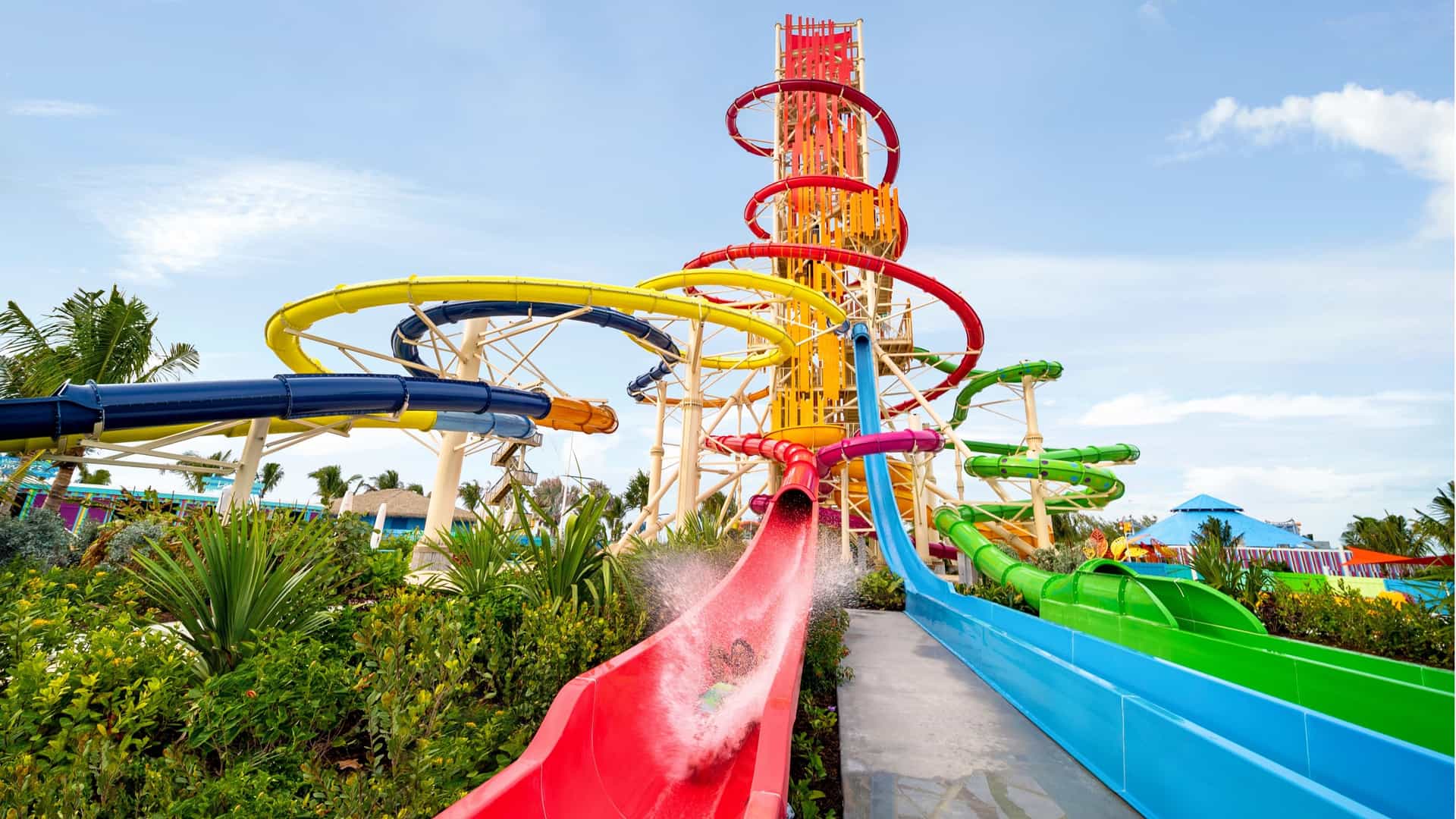 A child riding down a red waterslide in the Daredevil Tower at Cococay, Royal Caribbean's private island.