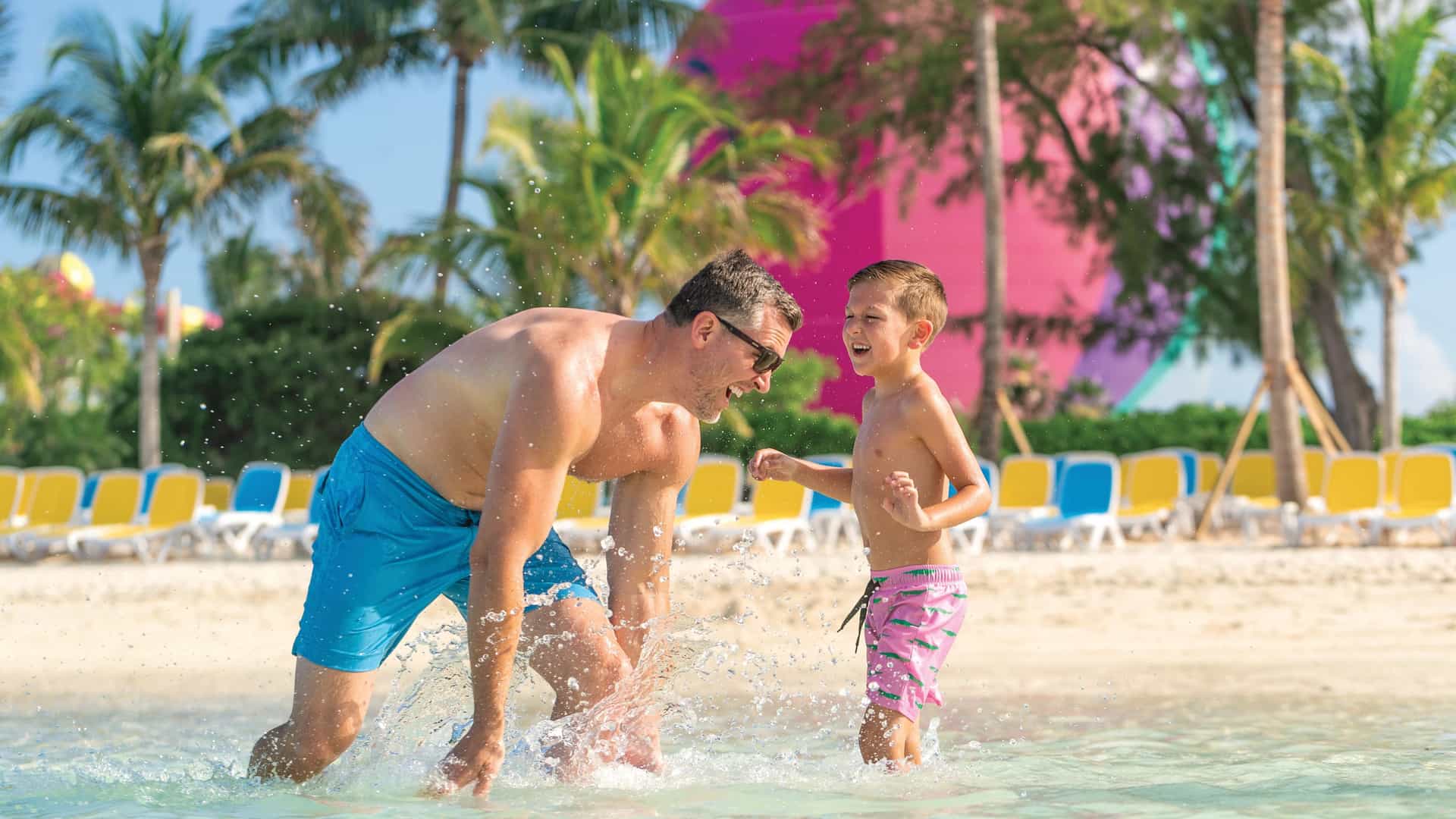 A father and son playing in the ocean on South Beach at Cococay, Royal Caribbean's private island.