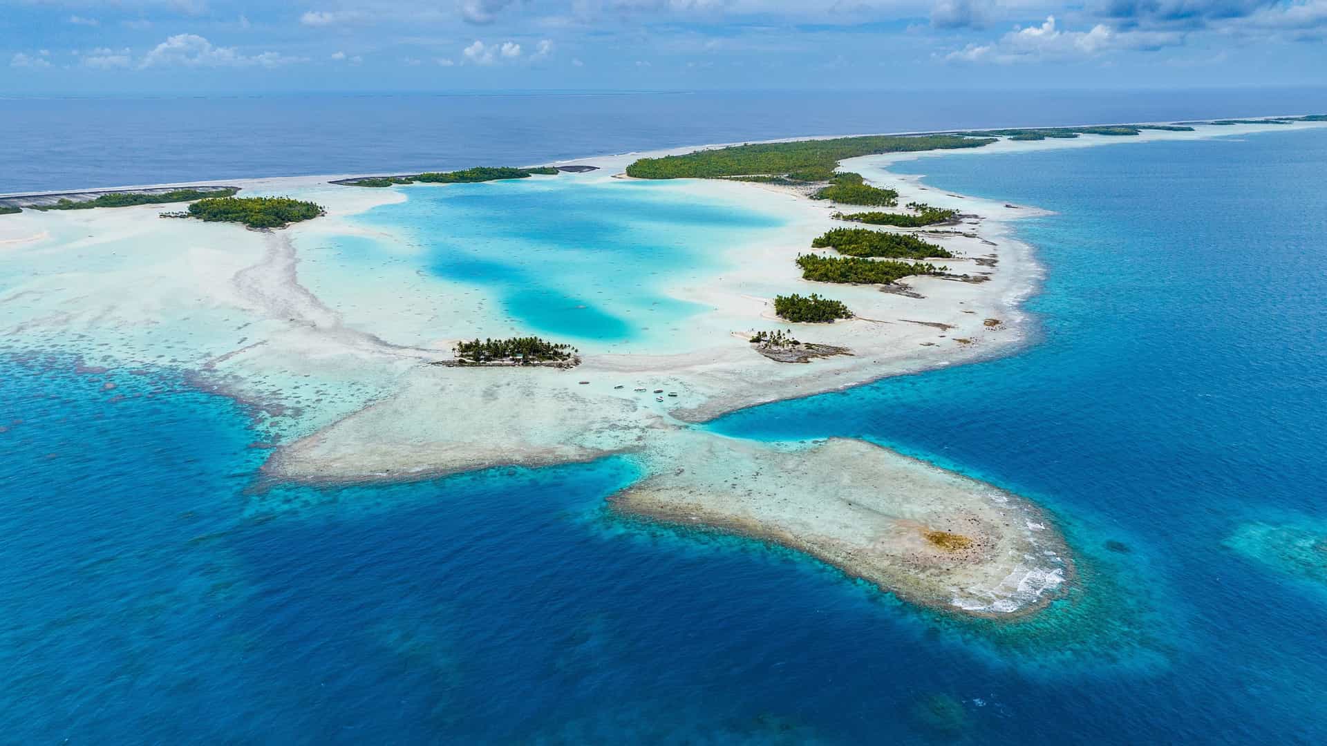 An aerial view of the stunning turquoise lagoon and sandy motus of Rangiroa Atoll in French Polynesia, a destination on a Silversea cruise.