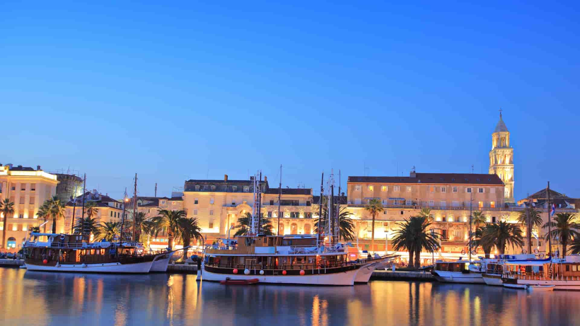 Split, Croatia harbor with Diocletian's Palace at dusk.