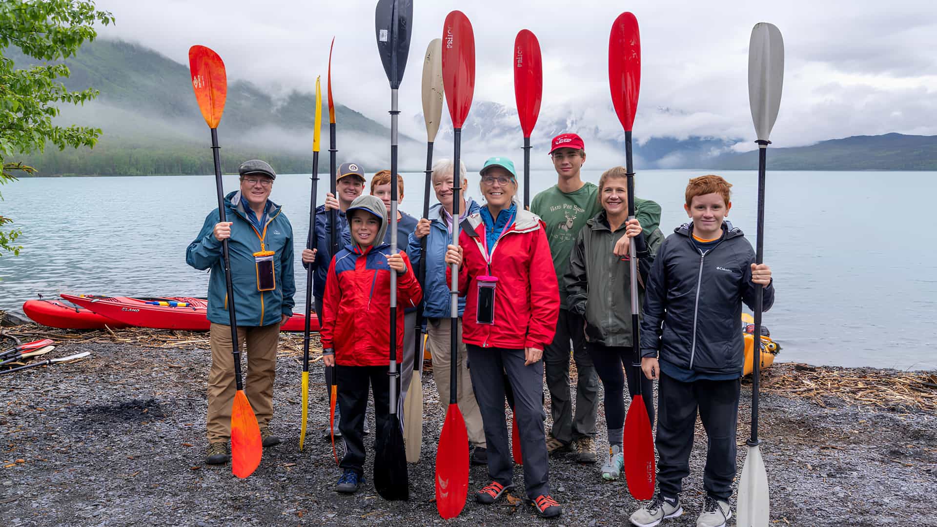 A family hoping paddles for kayaking in Alaska on a Tauck Bridges journey.
