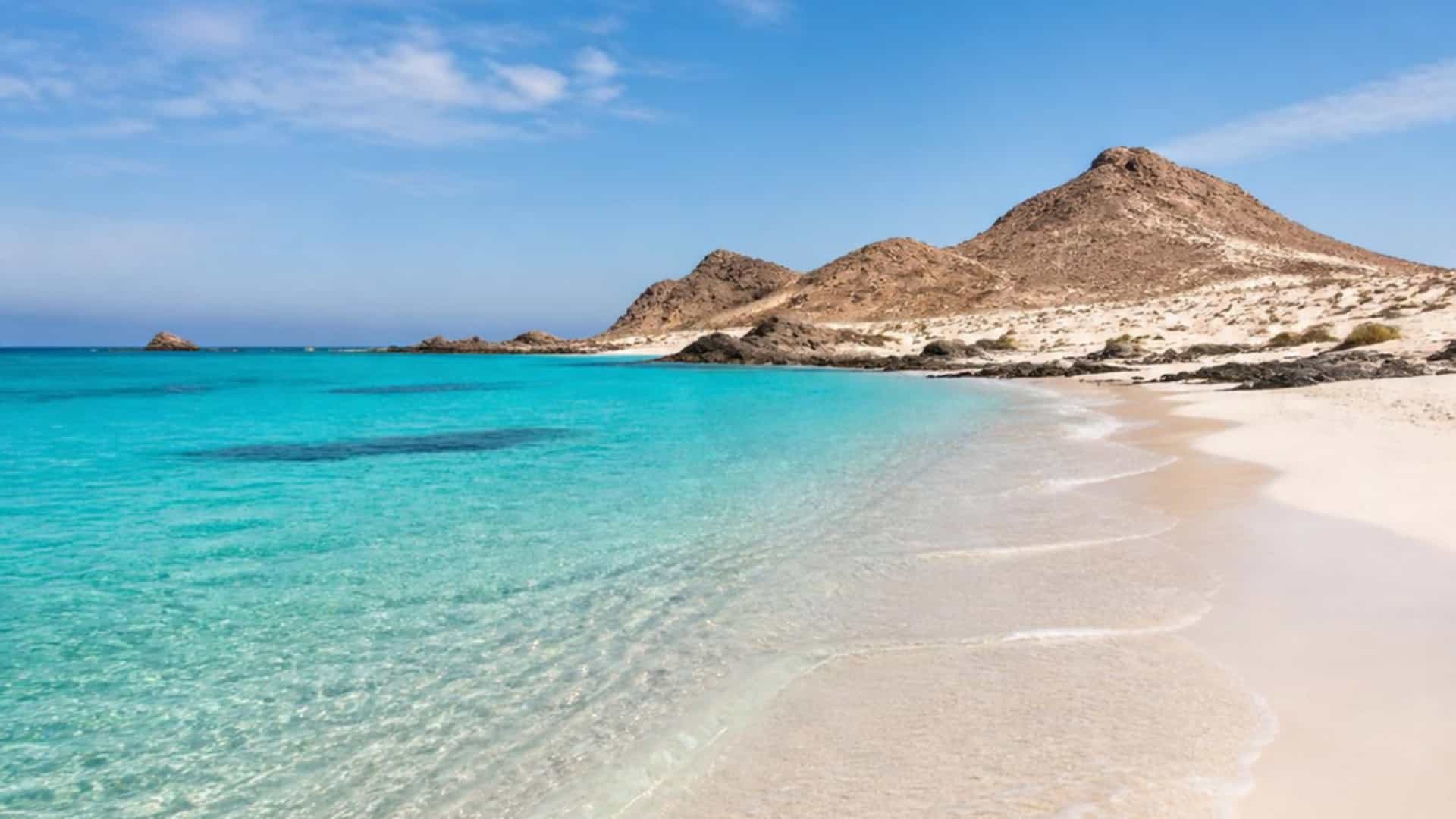 The pristine Red Sea island of Jabal Sabaya, Saudi Arabia, with white sand beach and turquoise water.