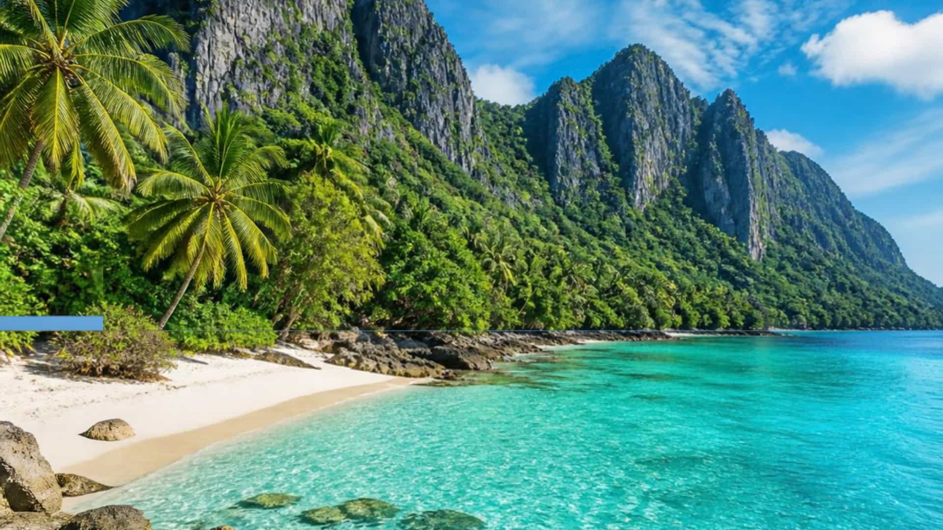 A tropical beach with turquoise water on the Gulf of Oman, backed by the rugged Hajar mountains at Khor Fakkan, UAE.
