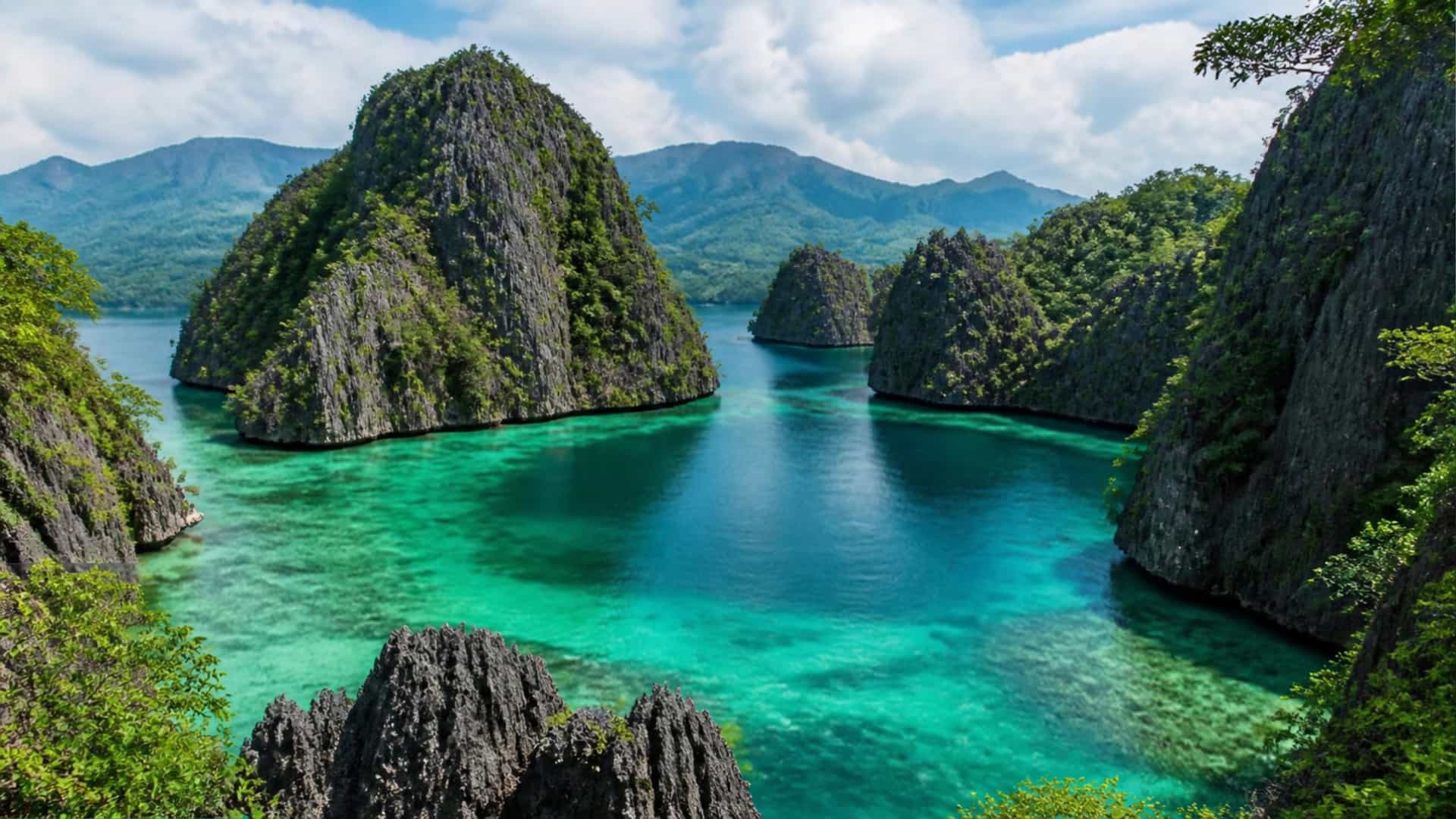 Hidden lagoons of Sohoton Bay, Philippines, with towering karst cliffs and emerald water.