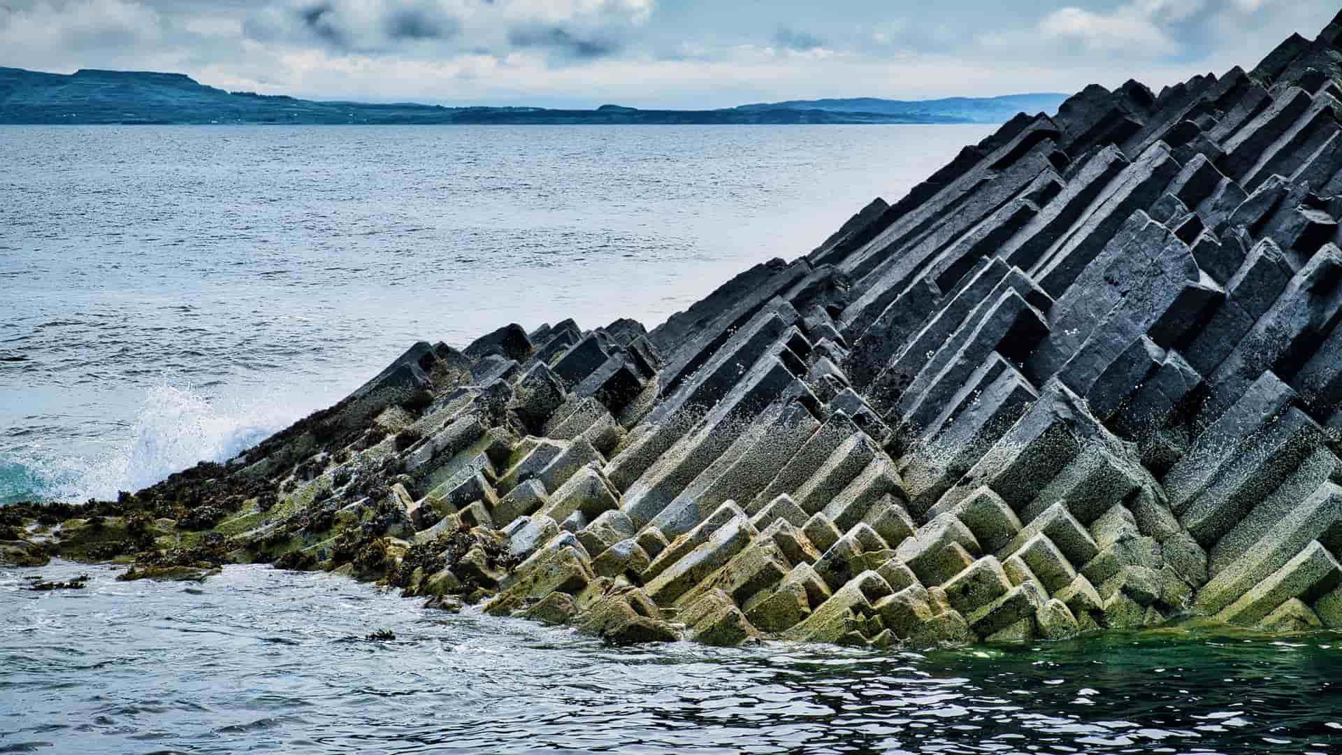 The distinct, angular basalt columns of the island of Staffa emerge from the sea.
