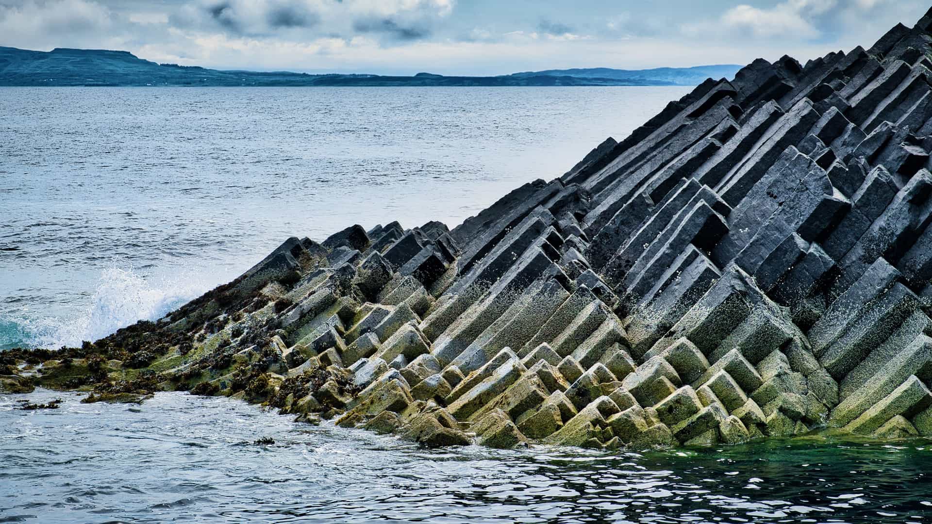 The distinct, angular basalt columns of the island of Staffa emerge from the sea.