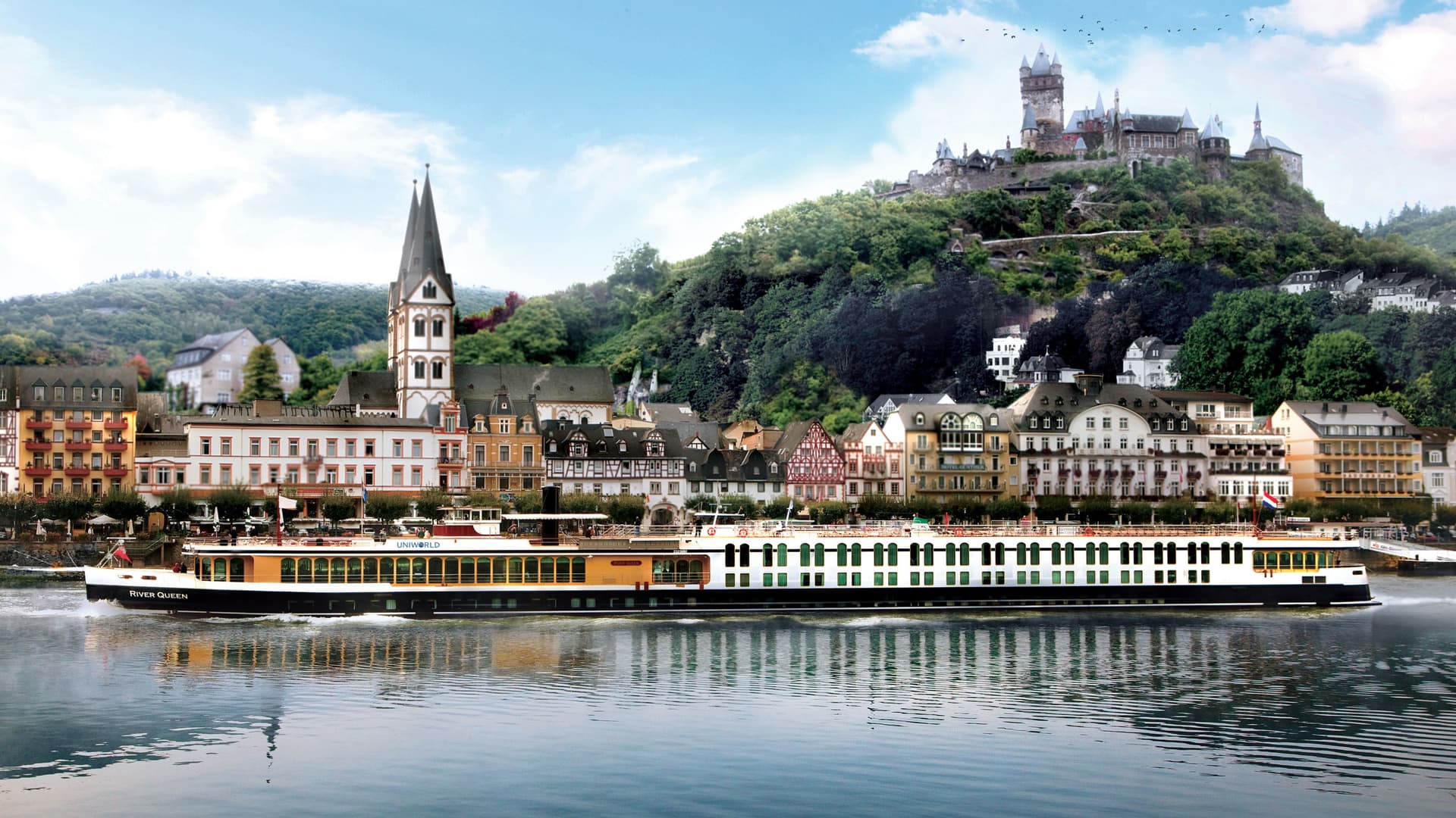 A Uniworld river ship glides smoothly down a European river with castles in the background.