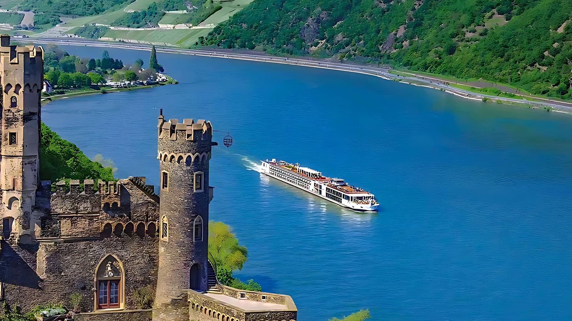 Aerial of Viking Gymir sailing a European river with a castle in the foreground.