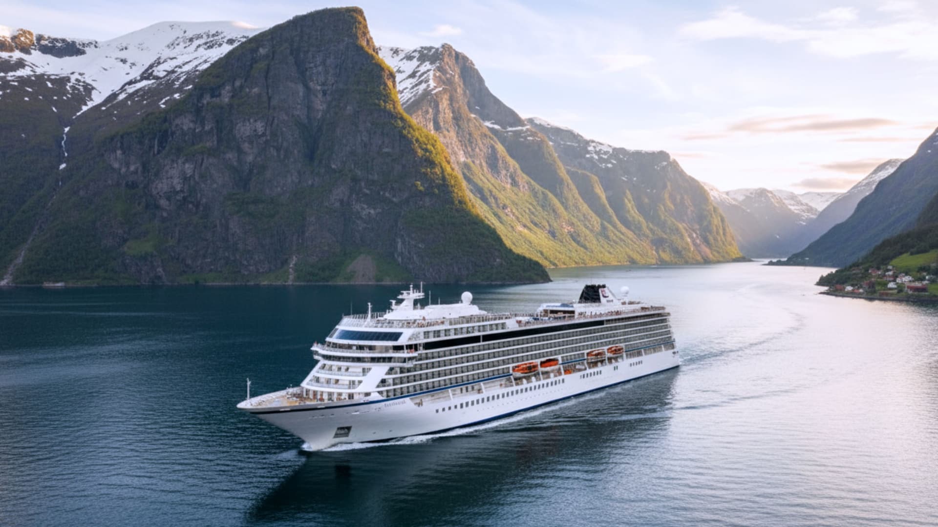 Viking Lyra ocean cruise ship sailing though with vast mountains in the background.
