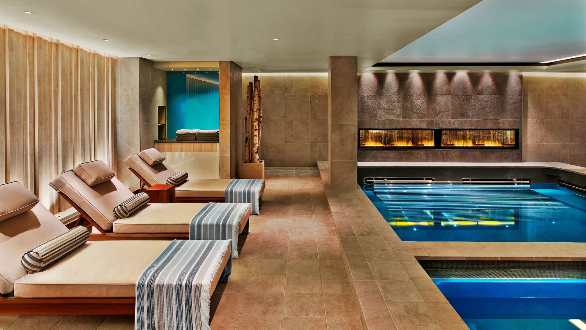 A side view of the spa, showcasing plush chairs, a swimming pool, and the modern touches of the architecture.