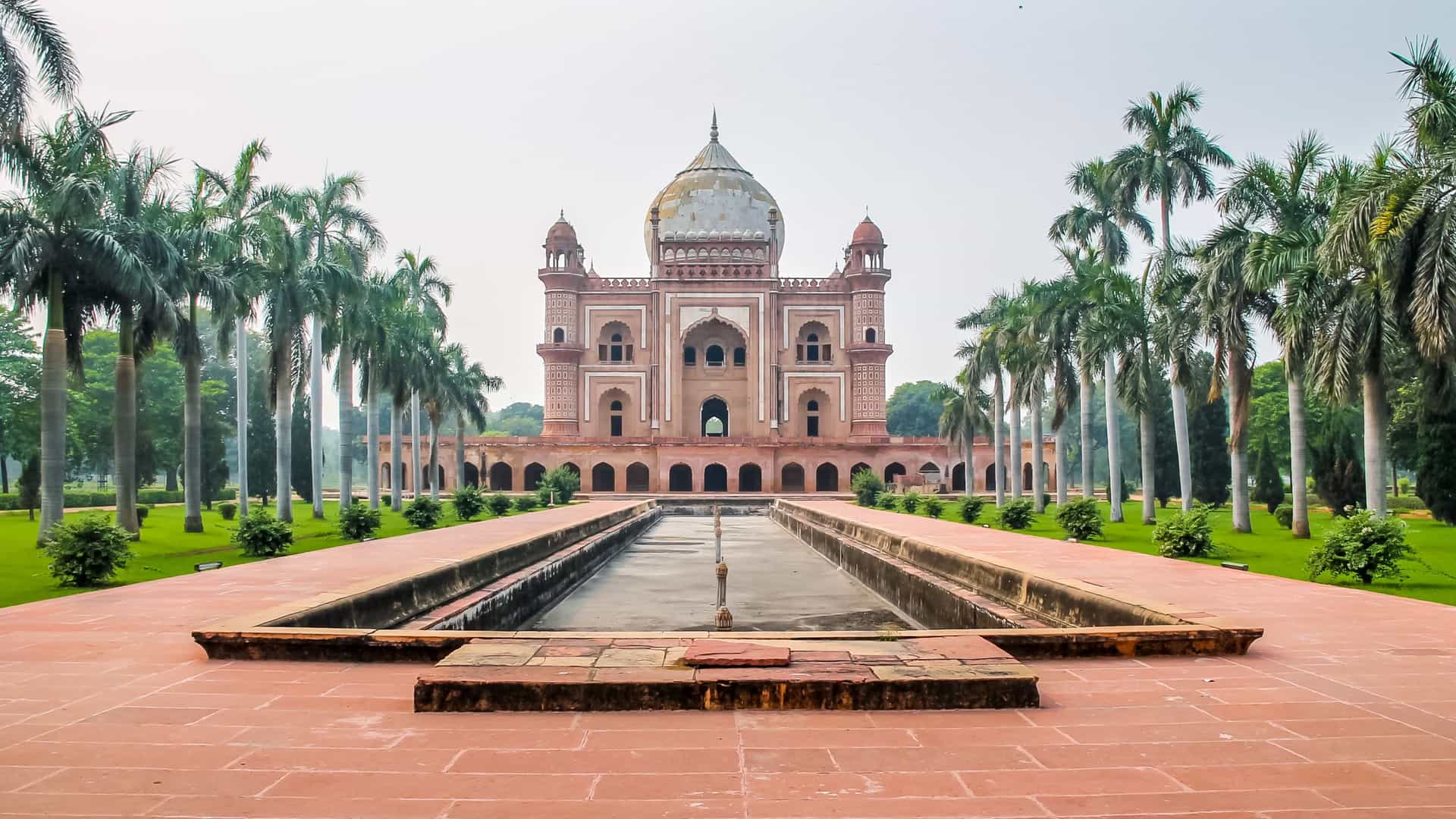 Safdarjung's Tomb in New Delhi, India, framed by palm trees and a reflecting pool—an elegant historical site featured on Viking River Cruises' South Asia itinerary.