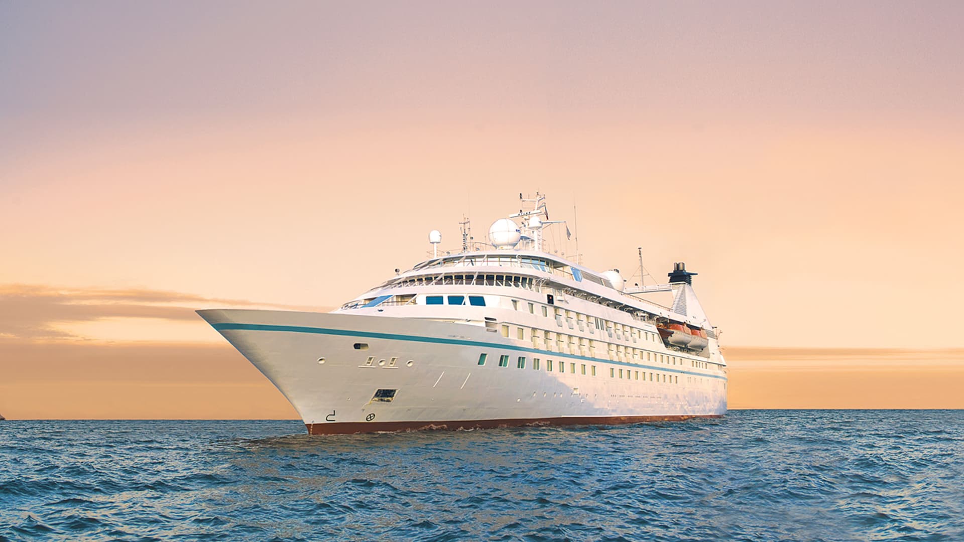 Windstar's Star Legend cruise ship sailing at sunset.