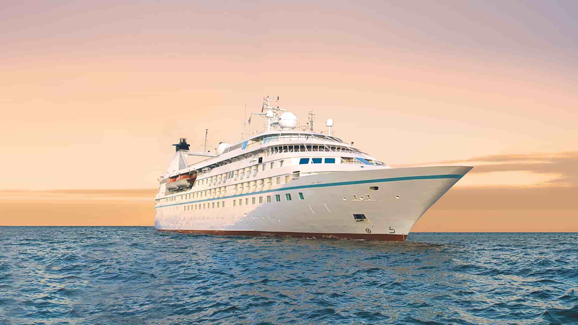 Windstar's Star Pride cruise ship sailing at sunset.