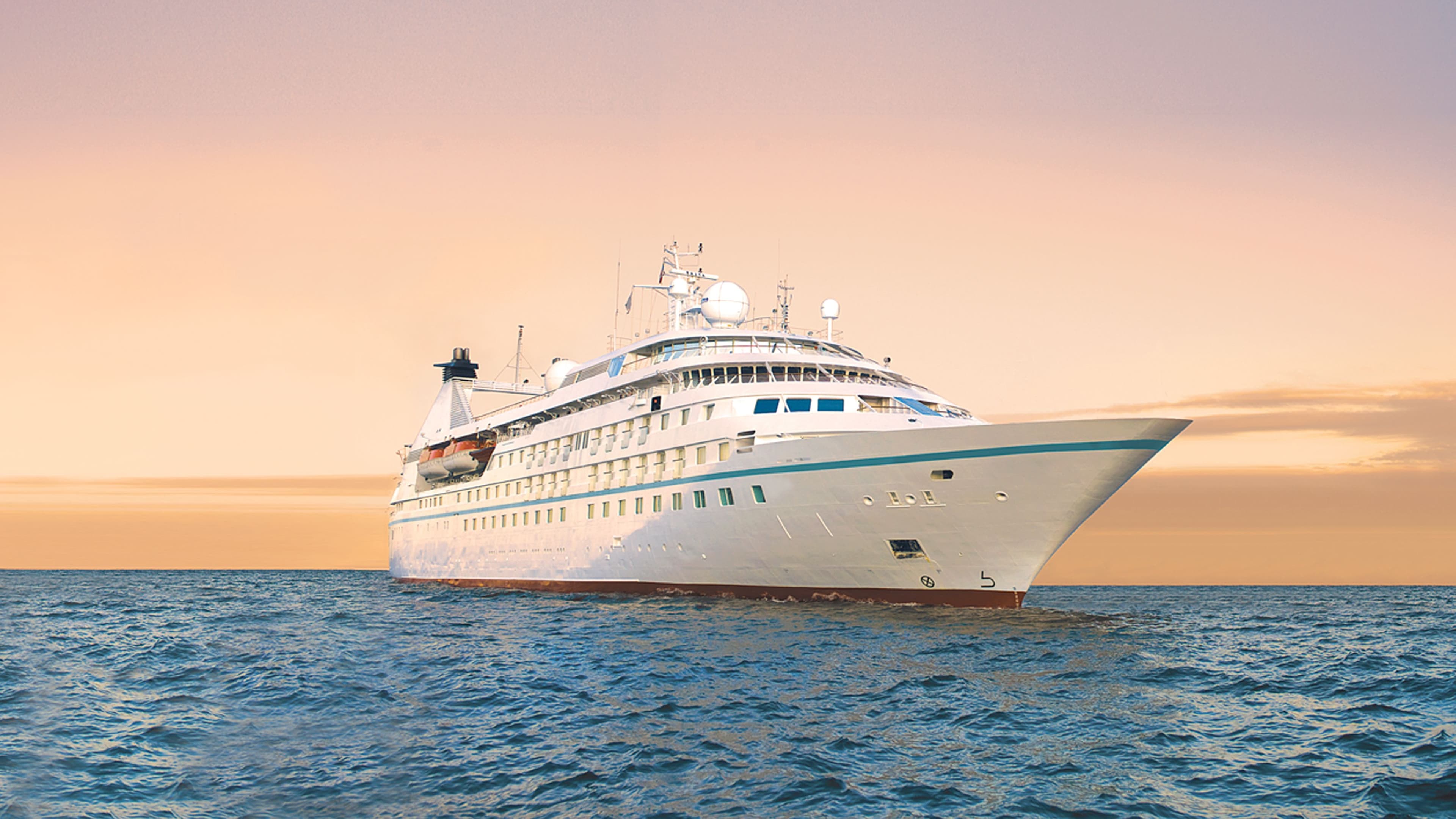 Windstar's Star Pride cruise ship sailing at sunset.